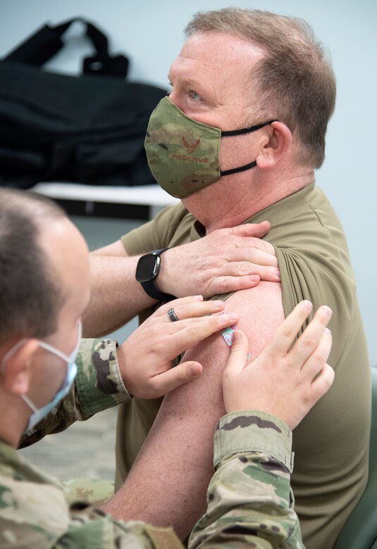 Chief of Air Force Reserve, Lt. Gen. Richard W. Scobee, has a bandaid placed over where he recived his second COVID-19 vaccine from Senior Airman Jarred Wright, an immunization technician with the 78th Medical Group, at Robins Air Force Base, Georgia, Feb. 4, 2021. The two-dose vaccines were recently approved by the Food and Drug Administration under an emergency use authorization and are currently offered to DoD personnel on a voluntary basis. (U.S. Air Force photo by Master Sgt. Stephen D. Schester)