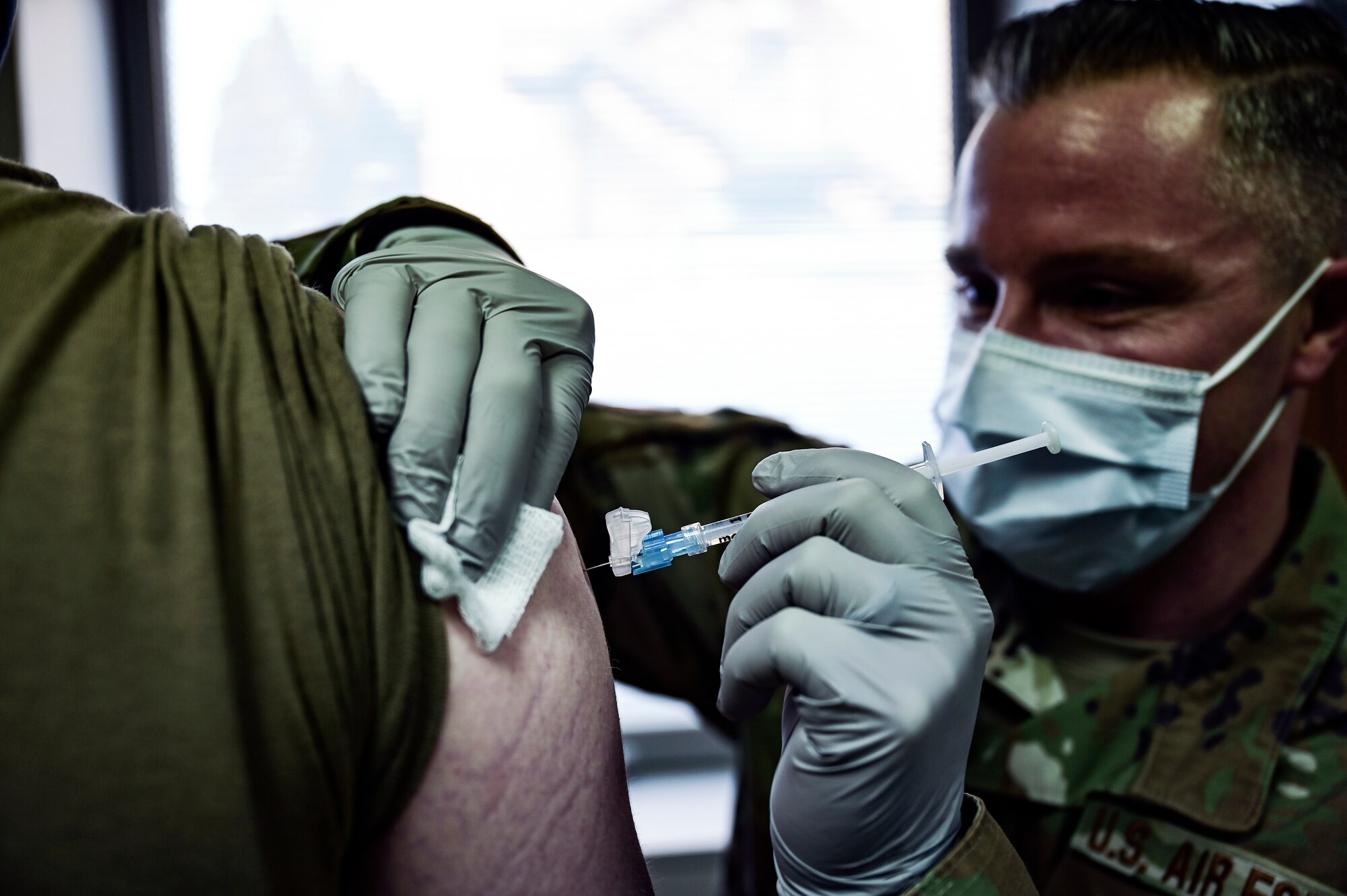 Tech. Sgt. Joseph Anthony, 911th Aeromedical Staging Squadron aeromedical technician, administers a COVID-19 vaccine to a member of the 911th Airlift Wing at the Pittsburgh International Airport Air Reserve Station, Pennsylvania, Feb. 4, 2021.