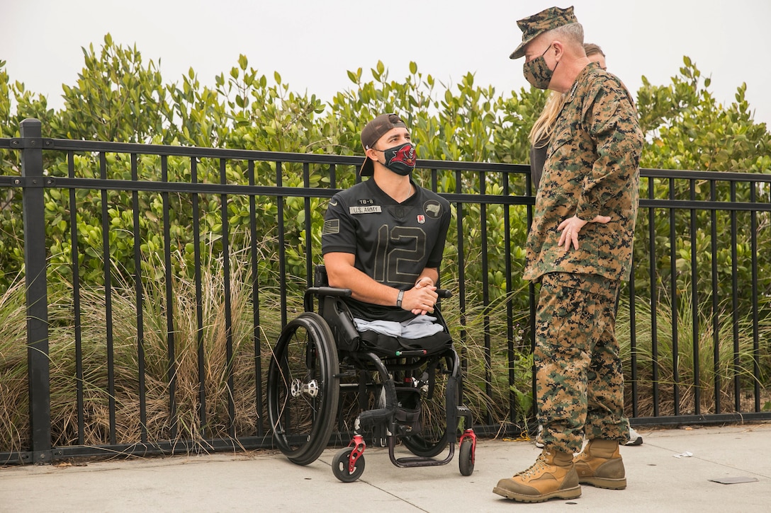 U.S. Marine Corps Gen. Kenneth F. McKenzie, Jr., the commander of U.S. Central Command, right, speaks with a U.S. military veteran before conducting the Wounded Warrior Amputee Dog Stroll in Tampa, Fl., Feb. 6, 2021. This event helps raise awareness of the need for service dogs for veterans at the Tampa Bay River Walk.  (U.S. Marine Corps photo by Sgt. Roderick Jacquote)