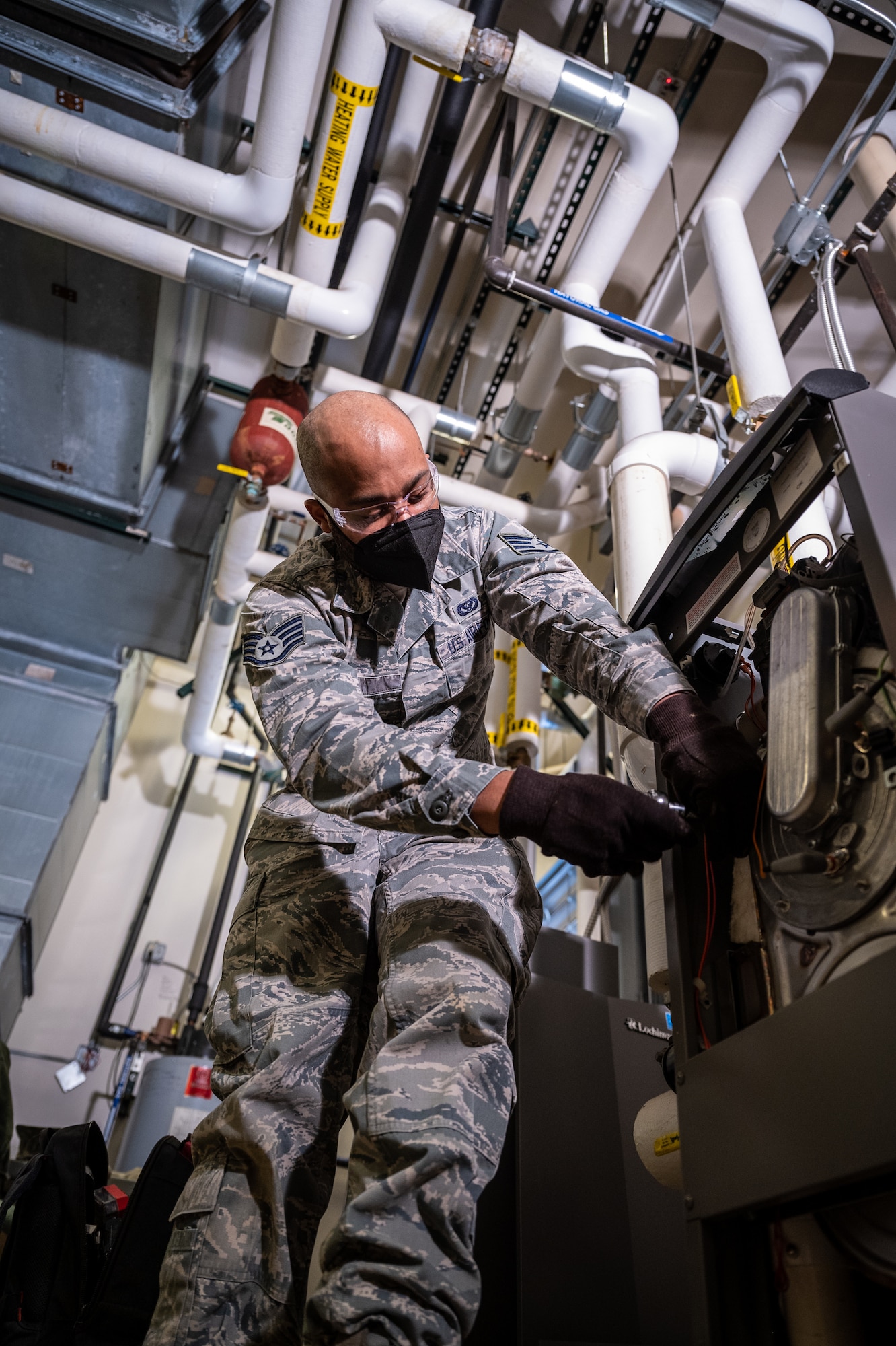 Staff Sgt. Keith Bell, 932nd Civil Engineer Squadron, heating, ventilation, and air conditioning craftsman removes screws holding the heating exchanger of a heating boiler, February 5, 2021, inside building 3651, the 932nd Medical Group building, Scott Air Force Base, Illinois.  The boiler requires annual maintenance, and the CES HVAC Airman were able to perform the maintenance to maintain their own readiness and support operations here at SAFB. (U.S. Air Force photo by Christopher Parr)