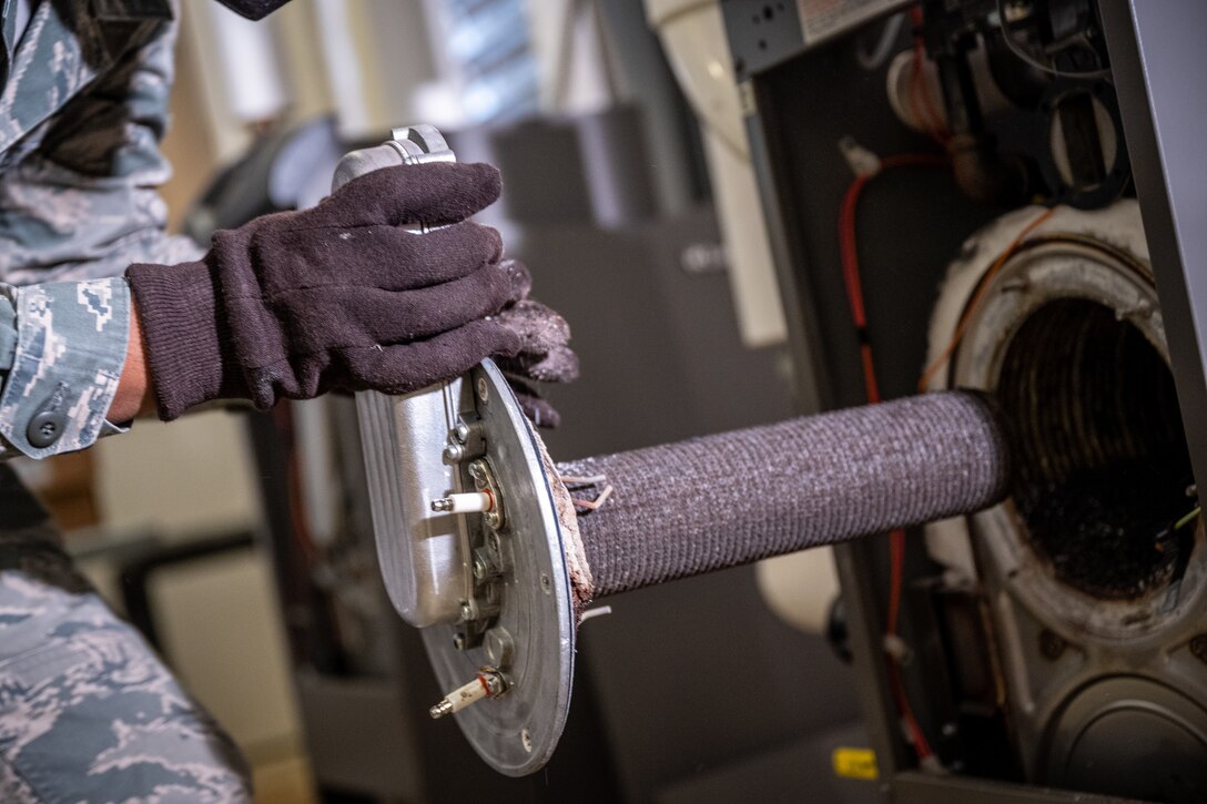 Staff Sgt. Keith Bell, 932nd Civil Engineer Squadron, heating, ventilation, and air conditioning craftsman removes the heating exchanger of a heating boiler, February 5, 2021, inside building 3651, the 932nd Medical Group building, Scott Air Force Base, Illinois. (U.S. Air Force photo by Christopher Parr)