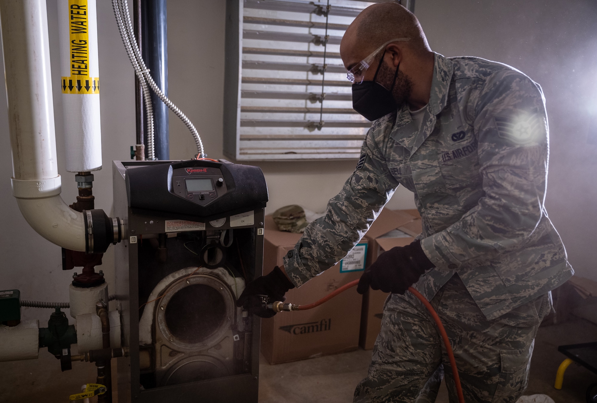 Staff Sgt. Keith Bell, 932nd Civil Engineer Squadron, heating, ventilation, and air conditioning craftsman cleans up the last of carbon buildup from a heating boiler using an air compressor February 5, 2021, inside building 3651, the 932nd Medical Group building, Scott Air Force Base, Illinois. (U.S. Air Force photo by Christopher Parr)