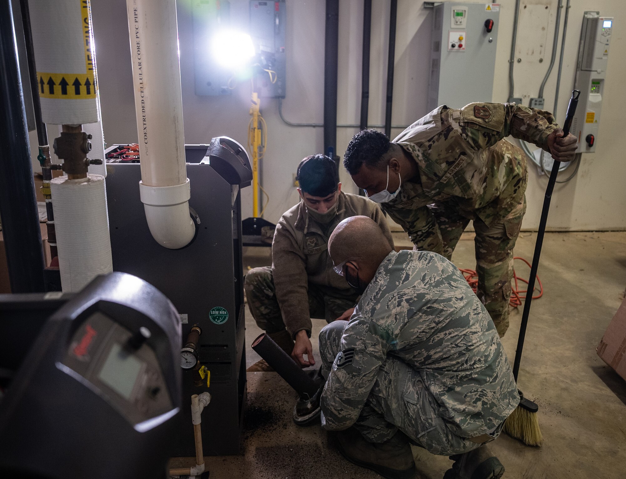 932nd Civil Engineer Squadron, heating, ventilation, and air conditioning Airmen inspect the heating exchange before replacing inside the heating boiler unit February 5, 2021, inside building 3651, the 932nd Medical Group building, Scott Air Force Base, Illinois.  (U.S. Air Force photo by Christopher Parr)