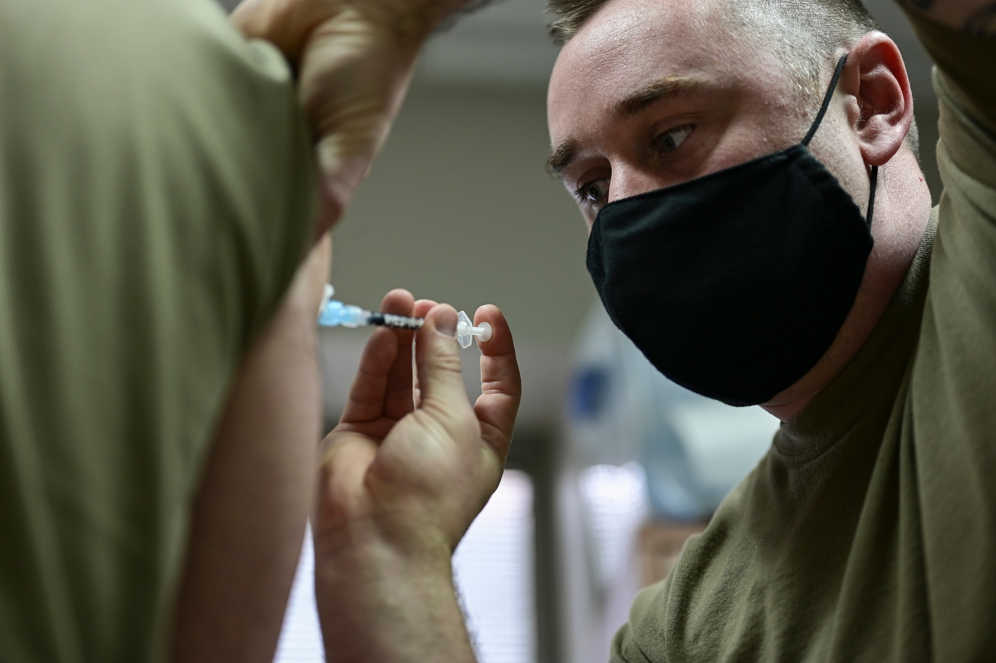 Staff Sgt. Stephen Barley, 911th Aeromedical Staging Squadron aeromedical technician, administers a COVID-19 vaccine to a member of the 911th Airlift Wing at the Pittsburgh International Airport Air Reserve Station, Pennsylvania, Jan. 28, 2021.