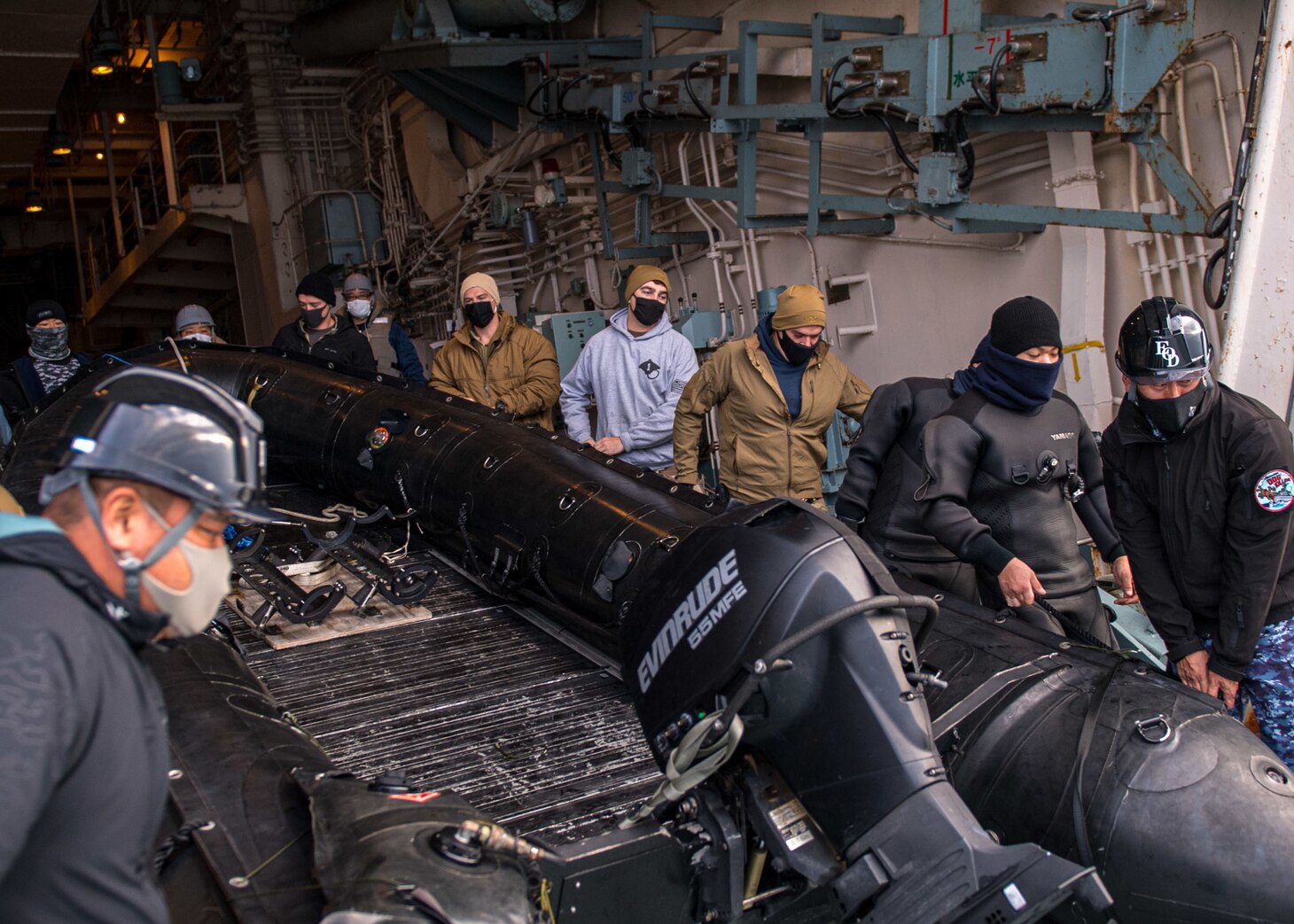 ISE BAY, Japan (Feb. 2, 2021) Sailors deployed with Mine Countermeasures Squadron 7 and members of the Japan Maritime Self-Defense Force (JMSDF) move a combat rubber raiding craft aboard minesweeper tender JS Uraga (MST 463) during Mine Warfare Exercise (MINEX) 1JA 2021. MINEX 1JA is part of an annual series of exercises between the U.S. Navy and JMSDF designed to increase proficiency in mine countermeasure operations. During the nine-day exercise, participants conduct unit-level mine warfare tactics to include mine hunting, detection, and prosecution. (U.S. Navy Photo by Mass Communication Specialist 2nd Class Nick Bauer)