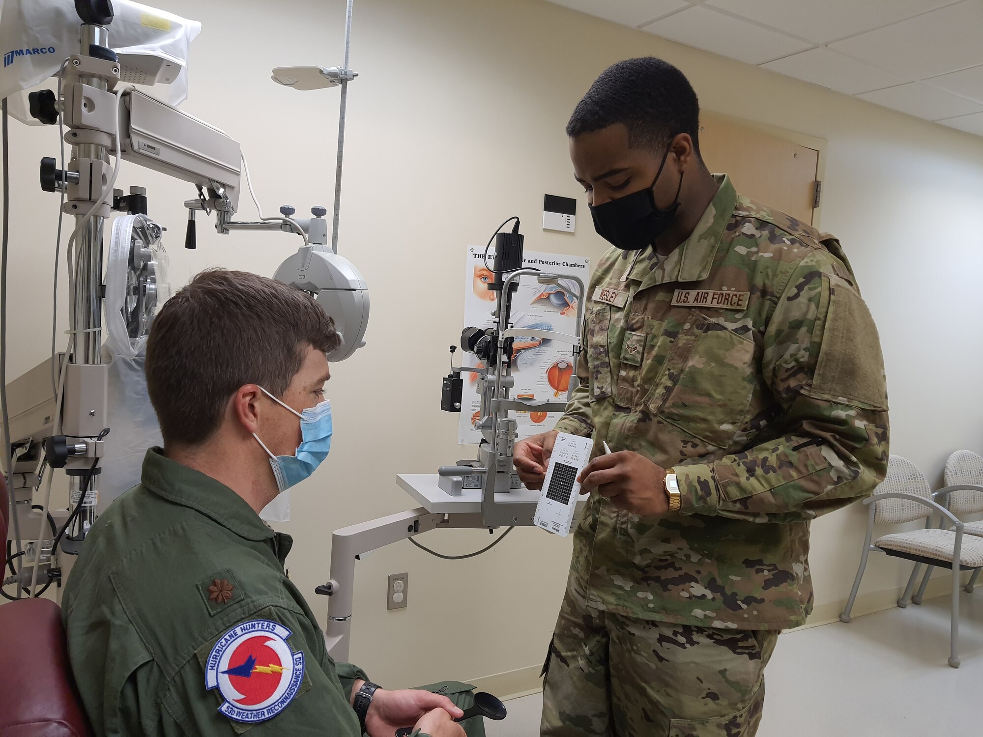 Airman 1st Class Jalen Wesley, 403rd Aeromedical Staging Squadron optometry technician, administers an Amsler grid eye exam, used to check central vision irregularities, to Maj. Wesley Dembek, 53rd Weather Reconnaissance Squadron pilot, Feb 6, 2021. The 403rd ASTS is responsible for ensuring that the Reserve Citizen Airmen of the 403rd Wing are current or 'green' on their Individual Medical Readiness status; which includes providing immunizations, optometry services, dental x-rays and exams, lab draws, audiograms, and physicals. (U.S. Air Force photo by Master Sgt. Jessica Kendziorek/ photo permission granted by Maj. Wesley Dembek)