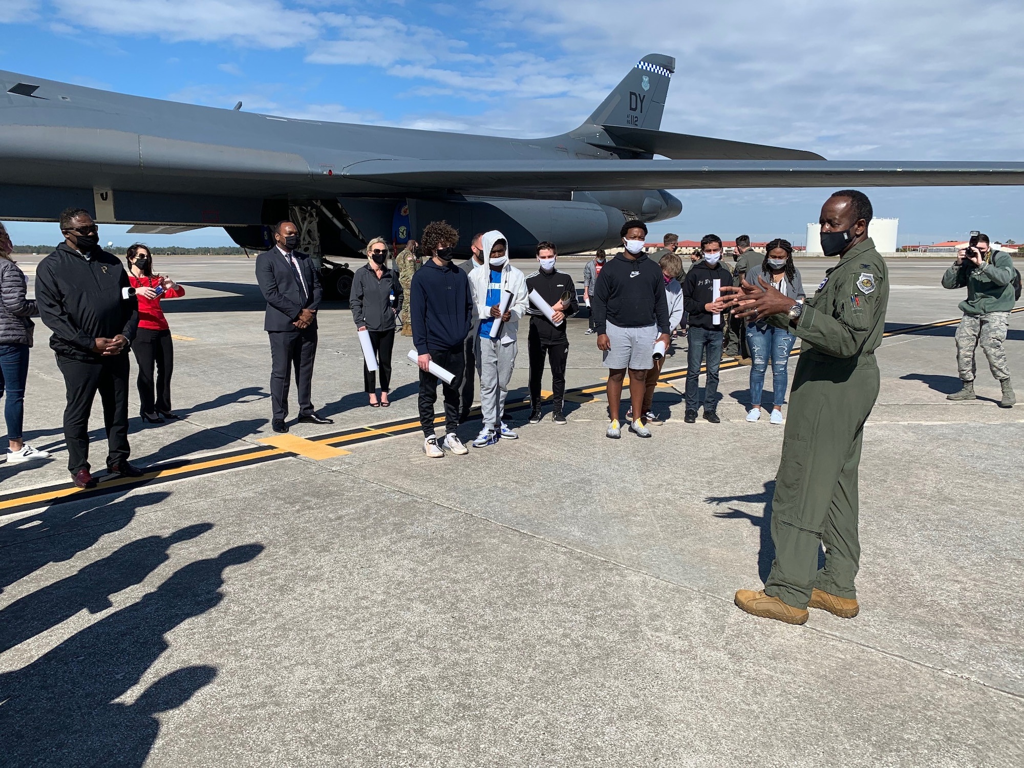 Air Force Col. Travis Edwards, 6th Operations Group commander, briefs Tampa Bay students on the MacDill Air Force Base, Florida flight line during a tour of a B-1B Lancer bomber and KC-135 Stratotanker aircraft Feb. 5, 2021. The students visited MacDill AFB to learn about the Air Force aircraft scheduled to fly over Raymond James Stadium during Super Bowl LV. The tour provided both male and female students from diverse multi-ethnic backgrounds in the community the opportunity to learn about the Air Force mission while sitting in the aircraft’s cockpit and visualizing themselves soaring at 35,000 feet in the air. (U.S. Air Force photo by Terry Montrose)