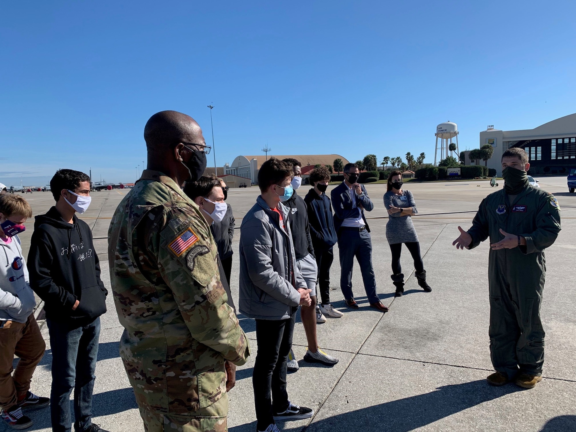 Air Force Maj. Patrick Burke, right, a B-1B Lancer bomber pilot from the 7th Bomb Wing, Dyess AFB, Texas, briefs Tampa Bay students on the MacDill Air Force Base, Florida flight line during a tour of a B-1B Lancer bomber and KC-135 Stratotanker aircraft Feb. 5, 2021. The students visited MacDill AFB to learn about the Air Force aircraft scheduled to fly over Raymond James Stadium during Super Bowl LV. The tour provided both male and female students from diverse multi-ethnic backgrounds in the community the opportunity to learn about the Air Force mission while sitting in the aircraft’s cockpit and visualizing themselves soaring at 35,000 feet in the air. (U.S. Air Force photo by Terry Montrose)
