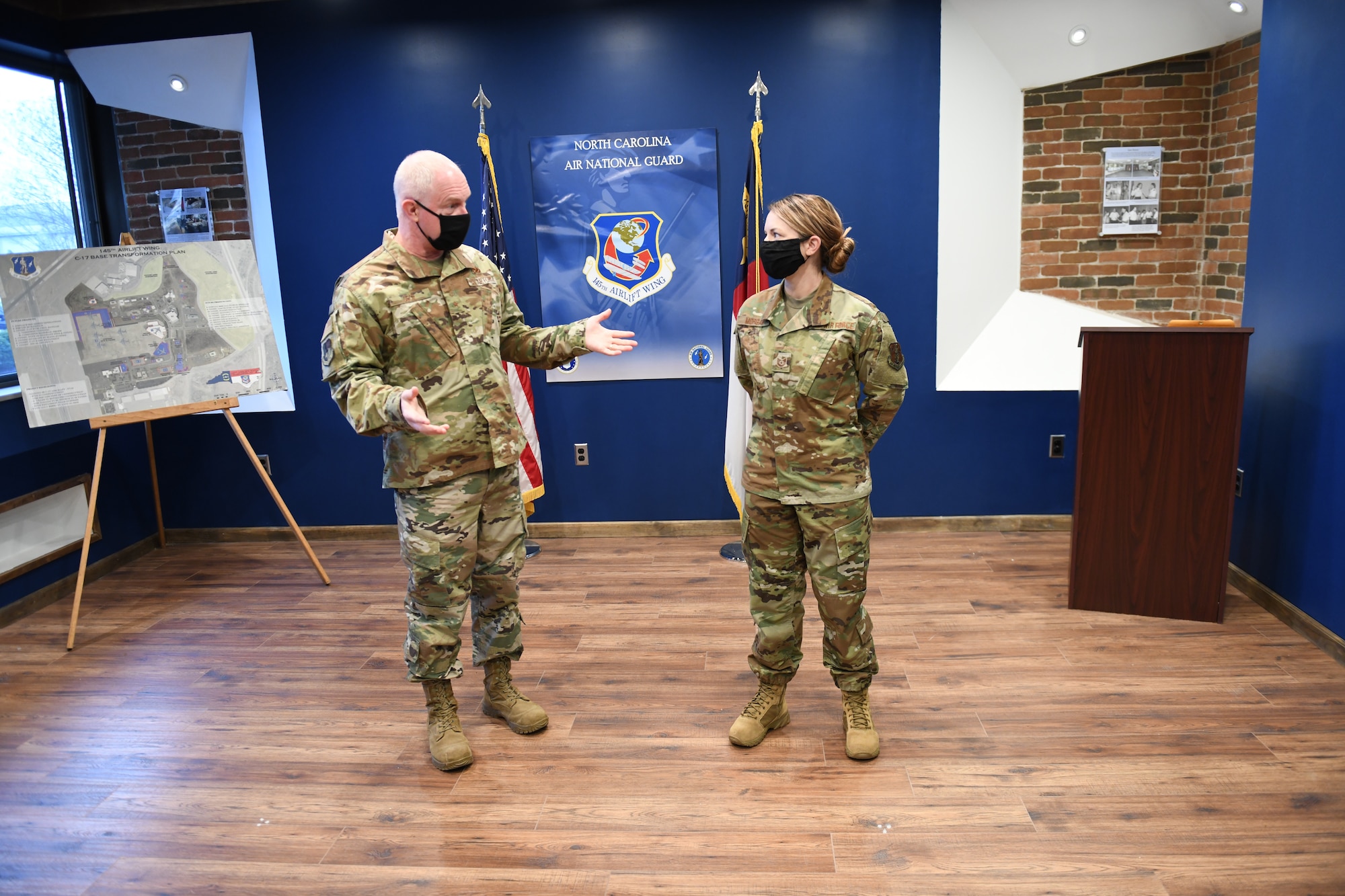 U.S. Air Force Brigadier General Allan R. Cecil North Carolina Air National Guard Chief of Staff (left), and TSgt Brittney Morgan a recruiter with the 145th Airlift Wing stand together before a coin presentation at Wing Headquarters building, NCANG Base, Charlotte Douglas International Airport, February 7. 2021. Brigadier General Cecil is presenting TSgt Morgan with a coin in recognition of her outstanding performance as a recruiter, going above her yearly recruiting goal by 147% during 2020.