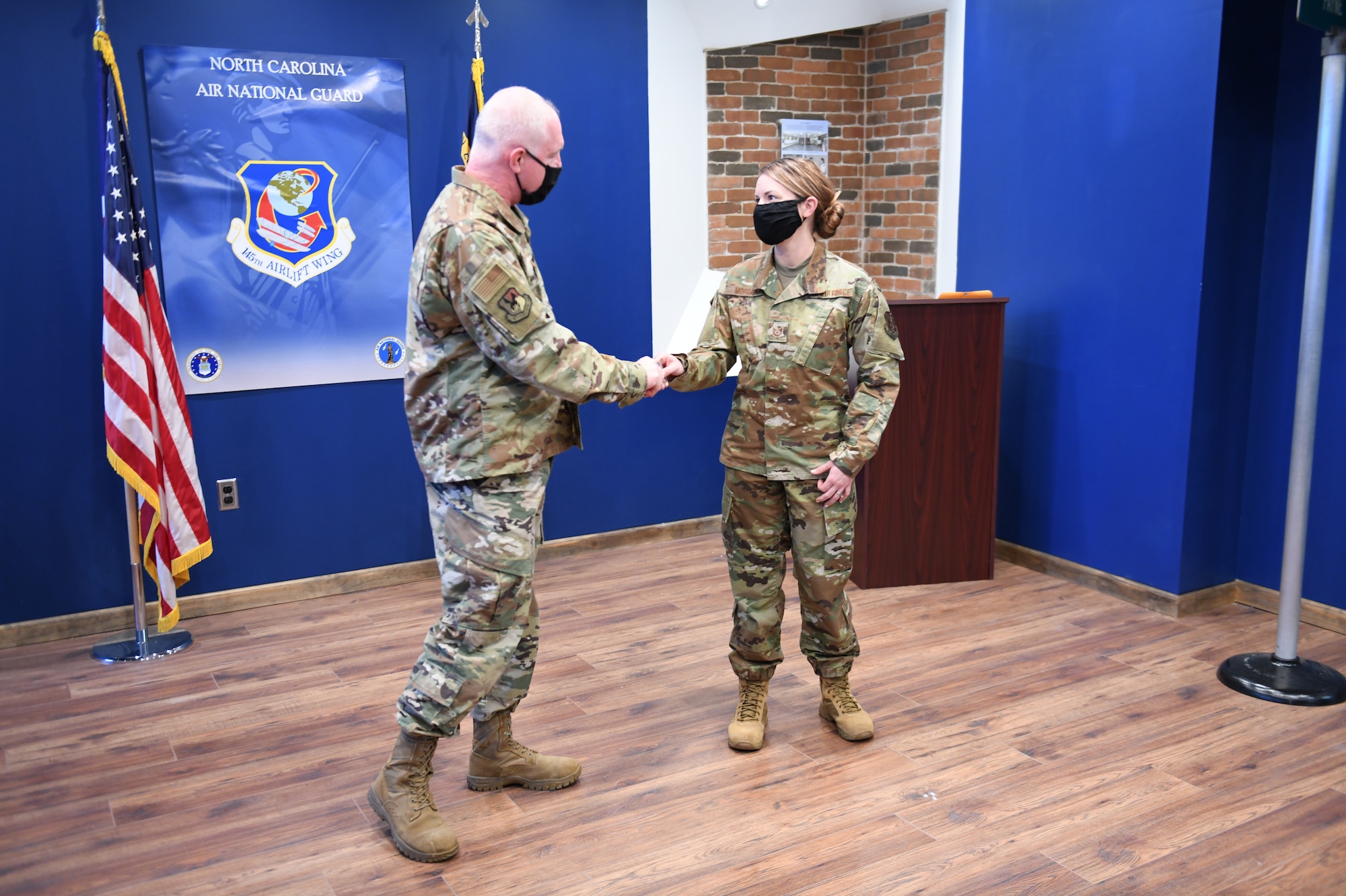 U.S. Air Force Brigadier General Allan R. Cecil North Carolina Air National Guard Chief of Staff (left), presents his coin to TSgt Brittney Morgan, a recruiter with the 145th Airlift Wing at the headquarters building, NCANG Base, Charlotte Douglas International Airport, February 7. 2021. Brigadier General Cecil is presenting TSgt Morgan with a coin in recognition of her outstanding performance as a recruiter, going above her yearly recruiting goal by 147% during 2020.