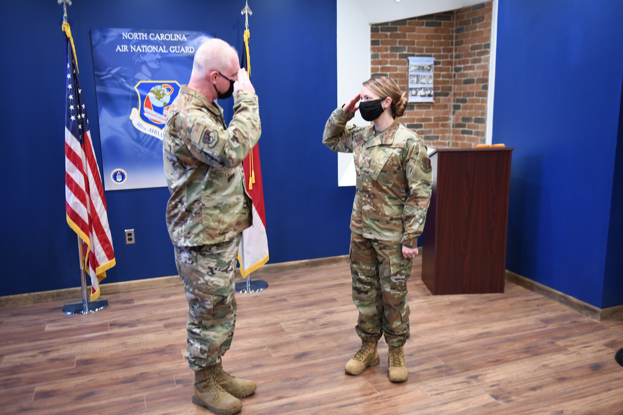 U.S. Air Force Brigadier General Allan R. Cecil North Carolina Air National Guard Chief of Staff (left), presents his coin to TSgt Brittney Morgan, a recruiter with the 145th Airlift Wing at the headquarters building, NCANG Base, Charlotte Douglas International Airport, February 7. 2021. Brigadier General Cecil is presenting TSgt Morgan with a coin in recognition of her outstanding performance as a recruiter, going above her yearly recruiting goal by 147% during 2020.