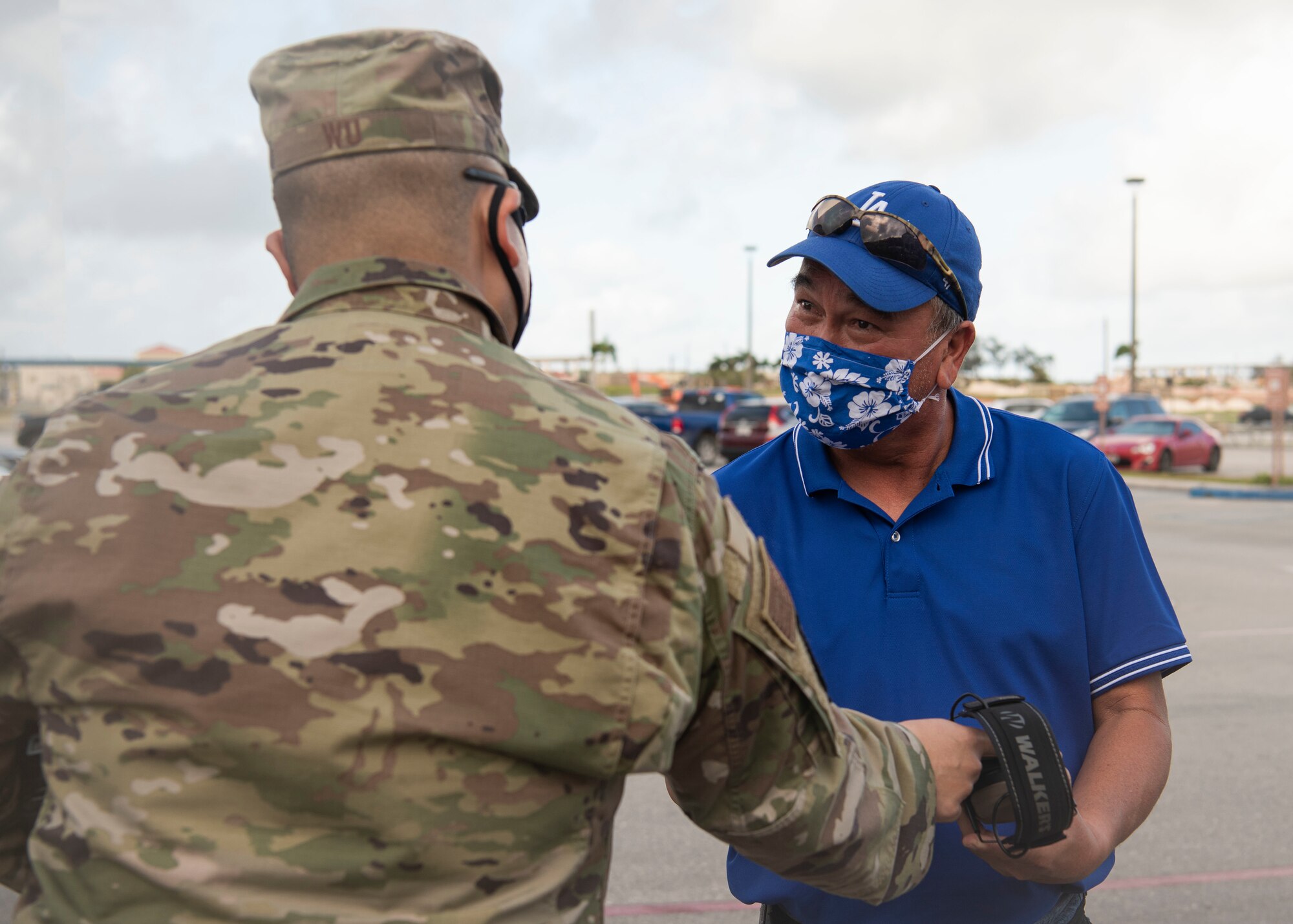 Maj. Timothy Wu, 36th Munitions Squadron commander, hands ear protection to the Honorable Anthony Sanchez, Yigo mayor, prior to a group flight line engagement during Exercise Cope North 2021 at Andersen Air Force Base, Guam, Feb. 5, 2021. Exercise Cope North 2021 is an annual U.S. Pacific Air Forces joint/combined, trilateral field training exercise occurring Feb. 3-19, 2021. (U.S. Air Force photo by Senior Airman Aubree Owens)