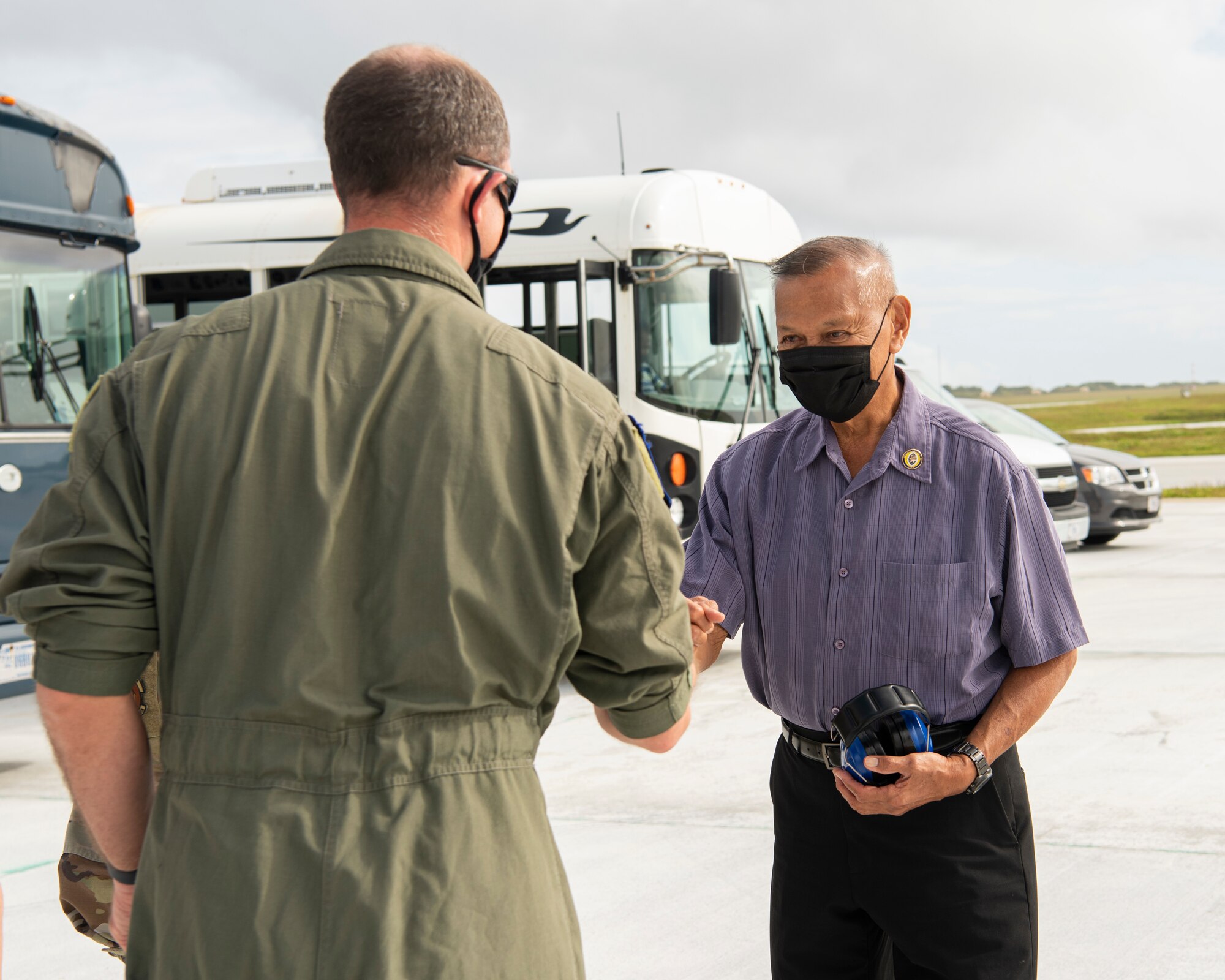 Lt. Col. Jeremy Stuursma, 36th Wing chief of safety, fist bumps the Honorable Frankie Salas, Asan-Maina mayor, when arriving at a group flight line engagement during Exercise Cope North 2021 at Andersen Air Force Base, Guam, Feb. 5, 2021. Exercise Cope North 2021 is an annual U.S. Pacific Air Forces joint/combined, trilateral field training exercise occurring Feb. 3-19, 2021. (U.S. Air Force photo by Senior Airman Aubree Owens)