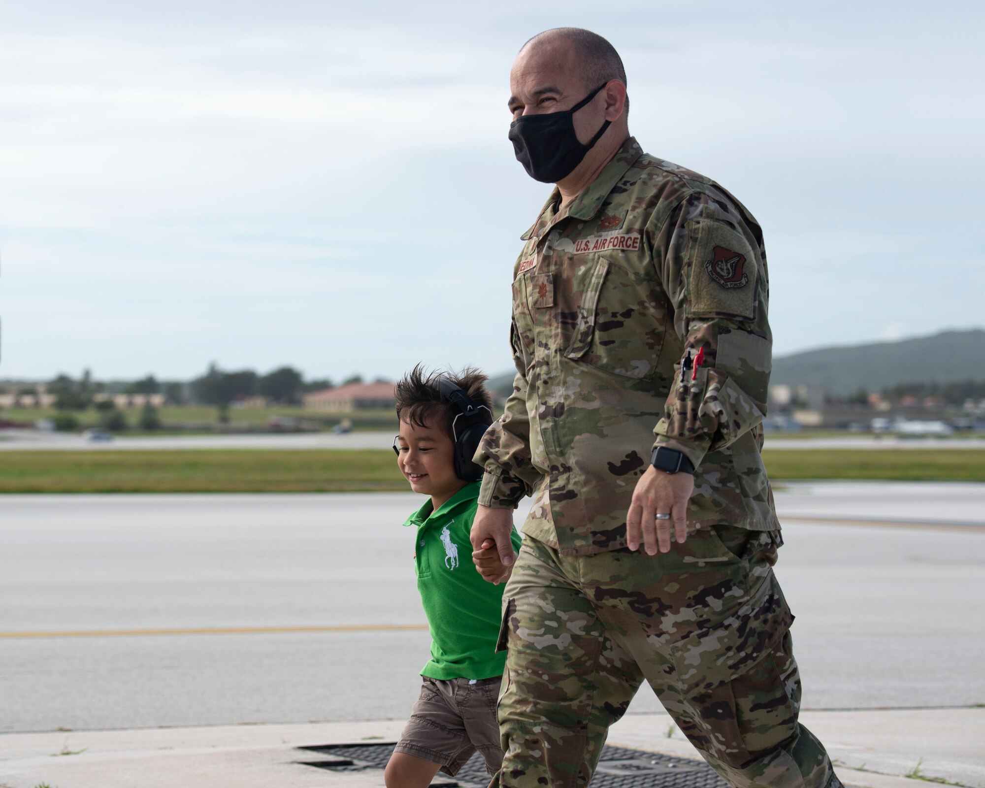 Maj. Elkin Medina 36th Expeditionary Aircraft Maintenance Squadron commander, walks with a fellow Airman's child during a group flight line engagement for Exercise Cope North 2021 at Andersen Air Force Base, Guam, Feb. 5, 2021. Exercise Cope North 2021 is an annual U.S. Pacific Air Forces joint/combined, trilateral field training exercise occurring Feb. 3-19, 2021. (U.S. Air Force photo by Senior Airman Aubree Owens)