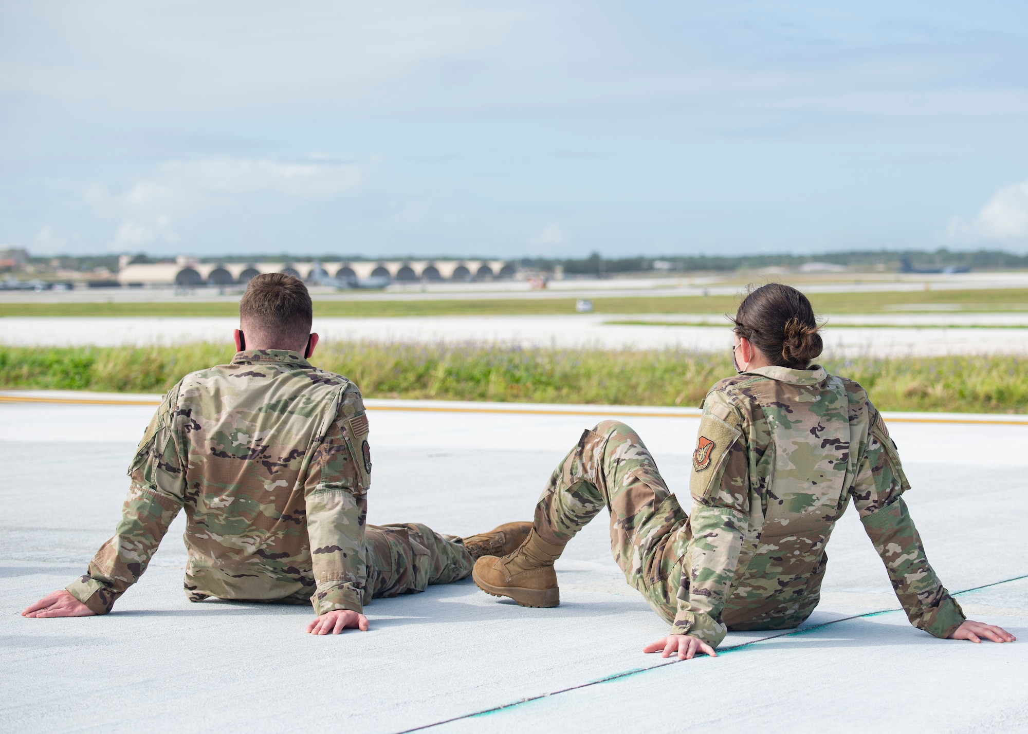 Two Airmen assigned to the 36th Maintenance Group watch aircraft take off during a group flight line engagement for Exercise Cope North 2021 at Andersen Air Force Base, Guam, Feb. 5, 2021. Exercise Cope North 2021 is an annual U.S. Pacific Air Forces joint/combined, trilateral field training exercise occurring Feb. 3-19, 2021. The exercise includes participants from the U.S. Air Force, U.S. Navy, U.S. Marine Corps, Japan Air Self-Defense Force and Royal Australian Air Force. (U.S. Air Force photo by Senior Airman Aubree Owens)