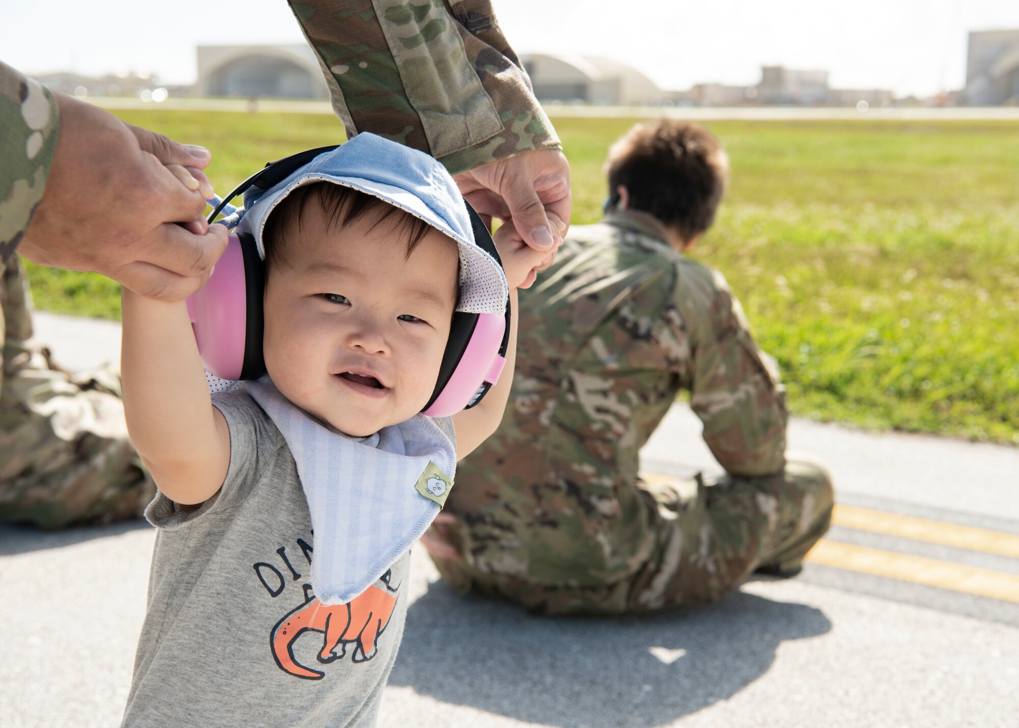 Maj. Timothy Wu holds his son’s hands while they watch aircraft take off during a group flight line engagement for Exercise Cope North 2021 at Andersen Air Force Base, Guam, Feb. 5, 2021. Exercise Cope North 2021is an annual U.S. Pacific Air Forces joint/combined, trilateral field training exercise occurring Feb. 3-19, 2021. (U.S. Air Force photo by Senior Airman Aubree Owens)