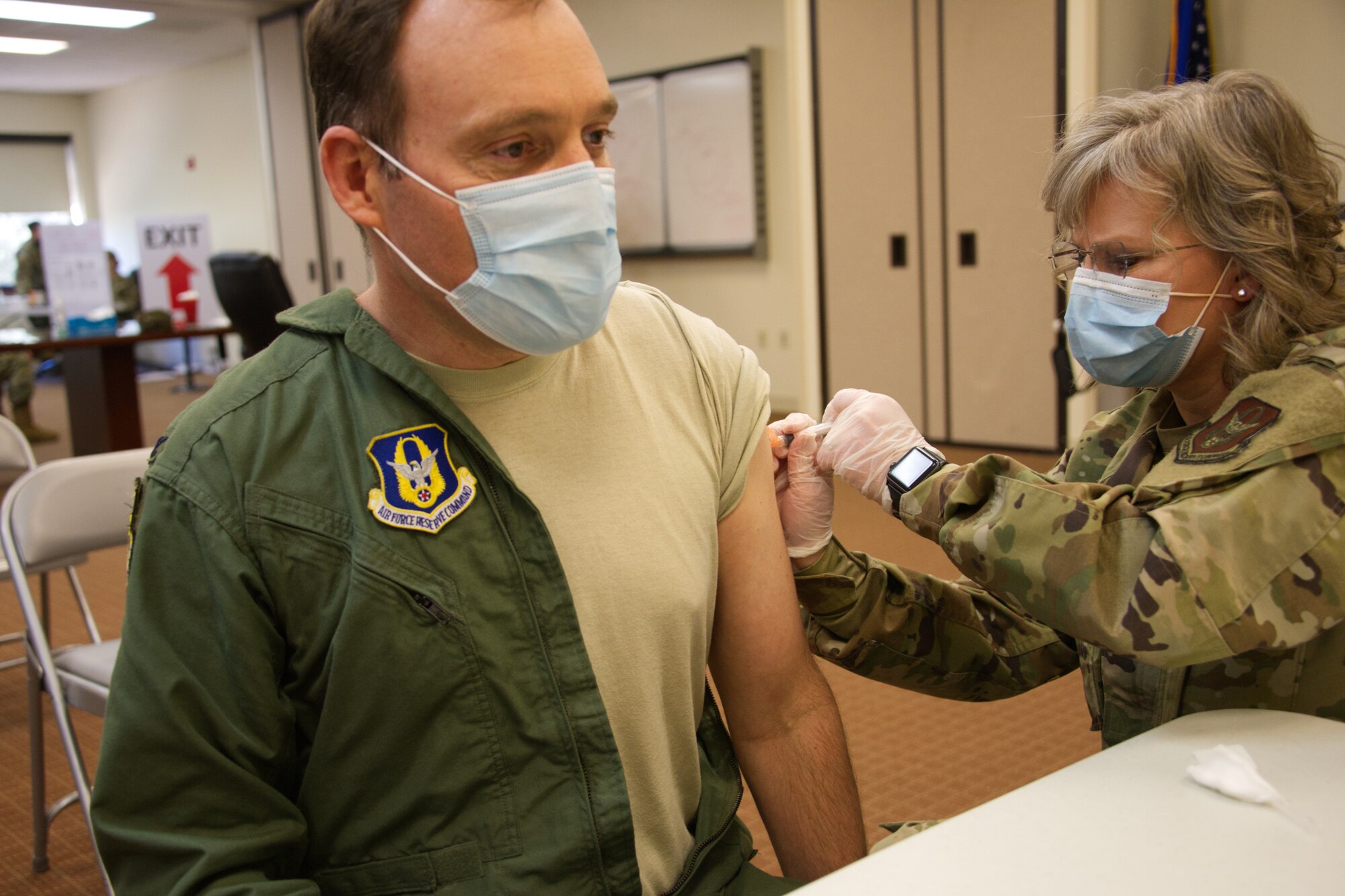 Photo of Airman with sleeve rolled up taking a shot.