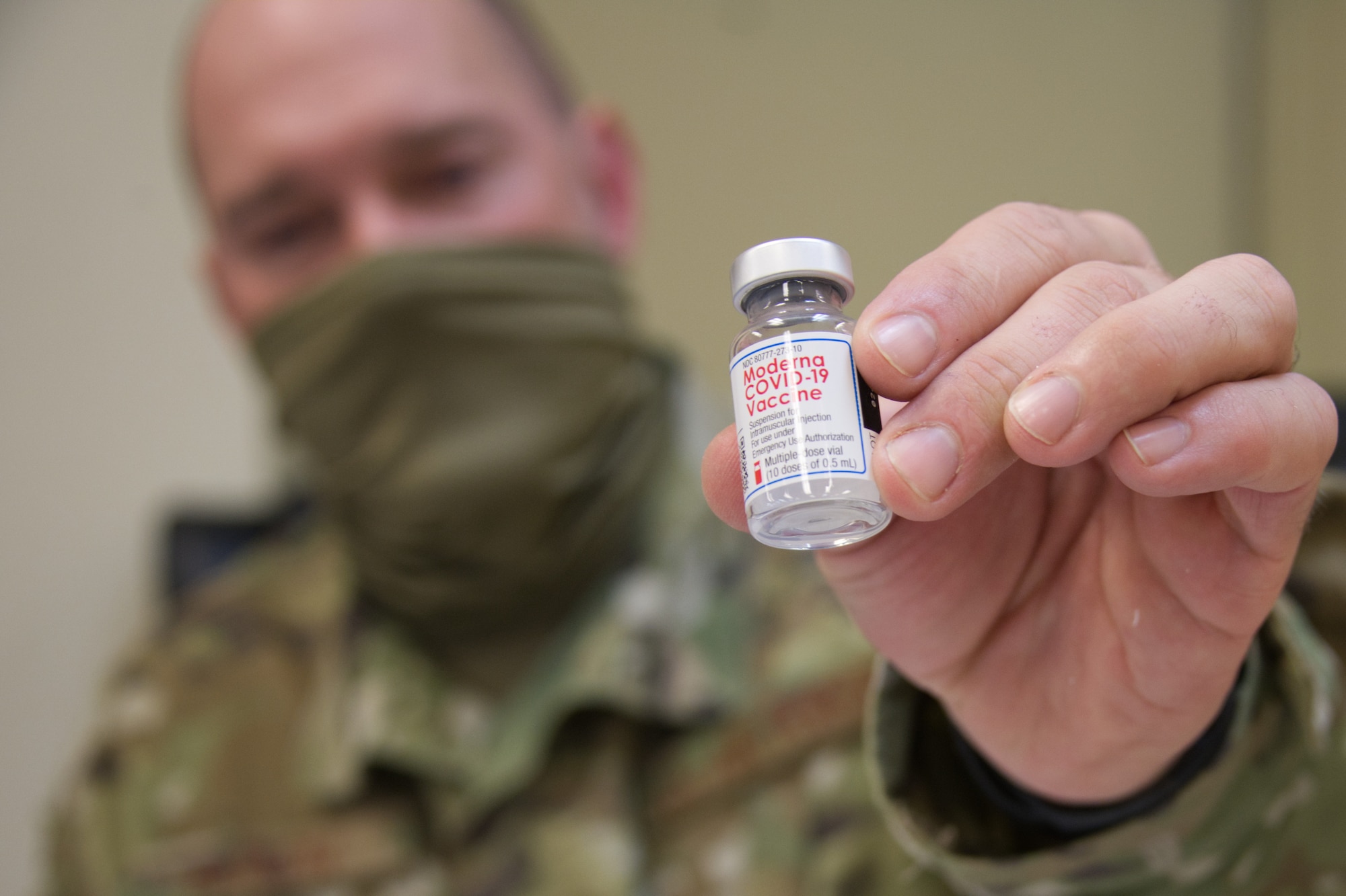 Airman holds a botte of COVID-19 vaccine.