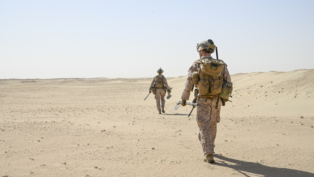 210130-M-ZN327-1067 CAMP BUEHRING, Kuwait (Jan. 30, 2021) – U.S. Marine Corps Sgt. Paul Daeth, right, and Staff Sgt. Benjamin Cosgrove, both explosive ordnance disposal technicians with Combat Logistics Battalion 15, 15th Marine Expeditionary Unit, patrol for simulated improvised explosive devices during a Theater Amphibious Combat Rehearsal (TACR) at Camp Buehring, Kuwait, Jan. 30. TACR integrates U.S. Navy and Marine Corps assets to practice and rehearse a range of critical combat-related capabilities available to U.S. Central Command, both afloat and ashore, to promote stability and security in the region. The 15th MEU is deployed to the U.S. 5th Fleet area of operations in support of naval operations to ensure maritime stability and security in the Central Region, connecting the Mediterranean and Pacific through the Western Indian Ocean and three strategic choke points. (U.S. Marine Corps photo by Cpl. Britany Rowlett)