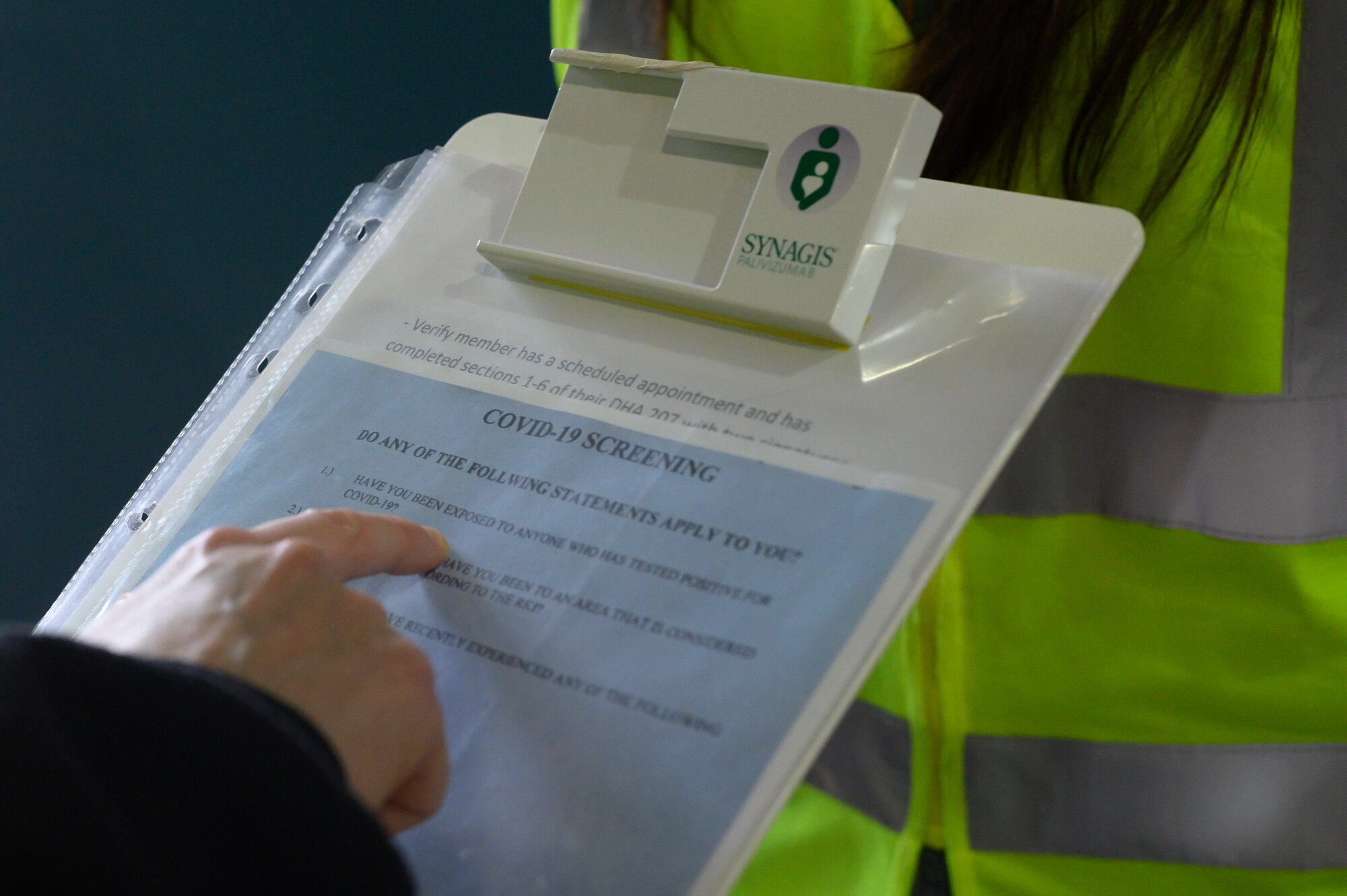 A photo of a clipboard detailing COVID-19 screening questions.