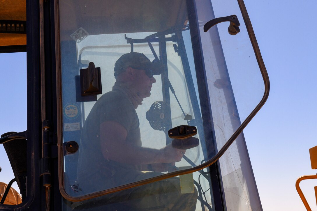 U.S. Air Force Master Sgt. Sean Kerrigan, 724th Expeditionary Air Base Squadron Civil Engineer Flight water and fuels maintenance shop supervisor, operates a backhoe to excavate dirt around a ruptured water main at Nigerien Air Base 201, Agadez, Niger, Feb. 2, 2021. The civil engineer flight worked to successfully locate a water main break on the logistics readiness flight compound. (U.S. Air Force photo by Senior Airman Gabrielle Winn)