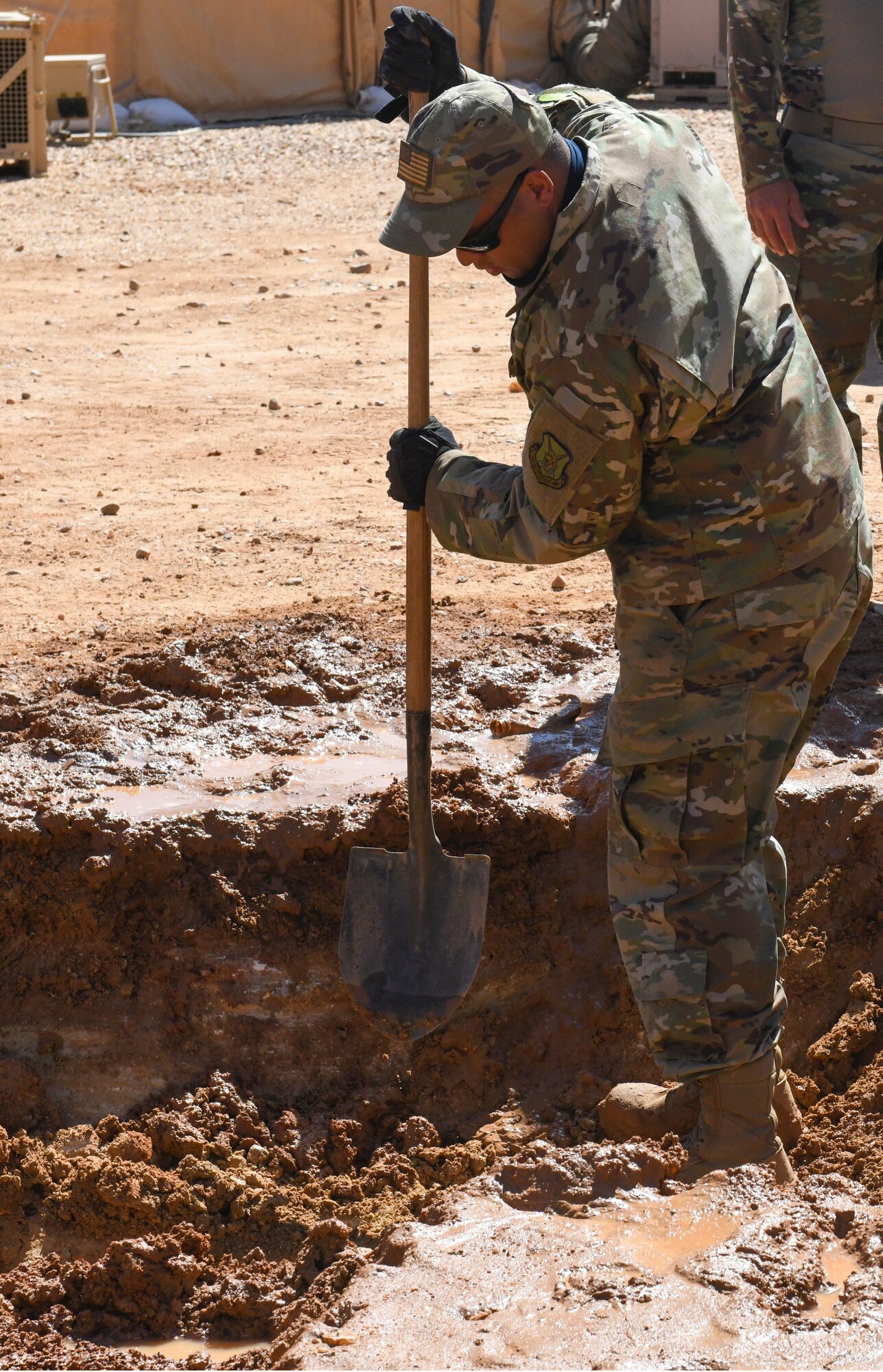 U.S. Air Force Master Sgt. Anthony Dangelo, 724th Expeditionary Air Base Squadron Civil Engineer Flight engineer assistant noncommissioned officer in charge, uses a shovel to locate a ruptured water main at Nigerien Air Base 201, Agadez, Niger, Feb. 2, 2021. A communications manhole overflowed with a mass amount of water due to a water main break. (U.S. Air Force photo by Senior Airman Gabrielle Winn)