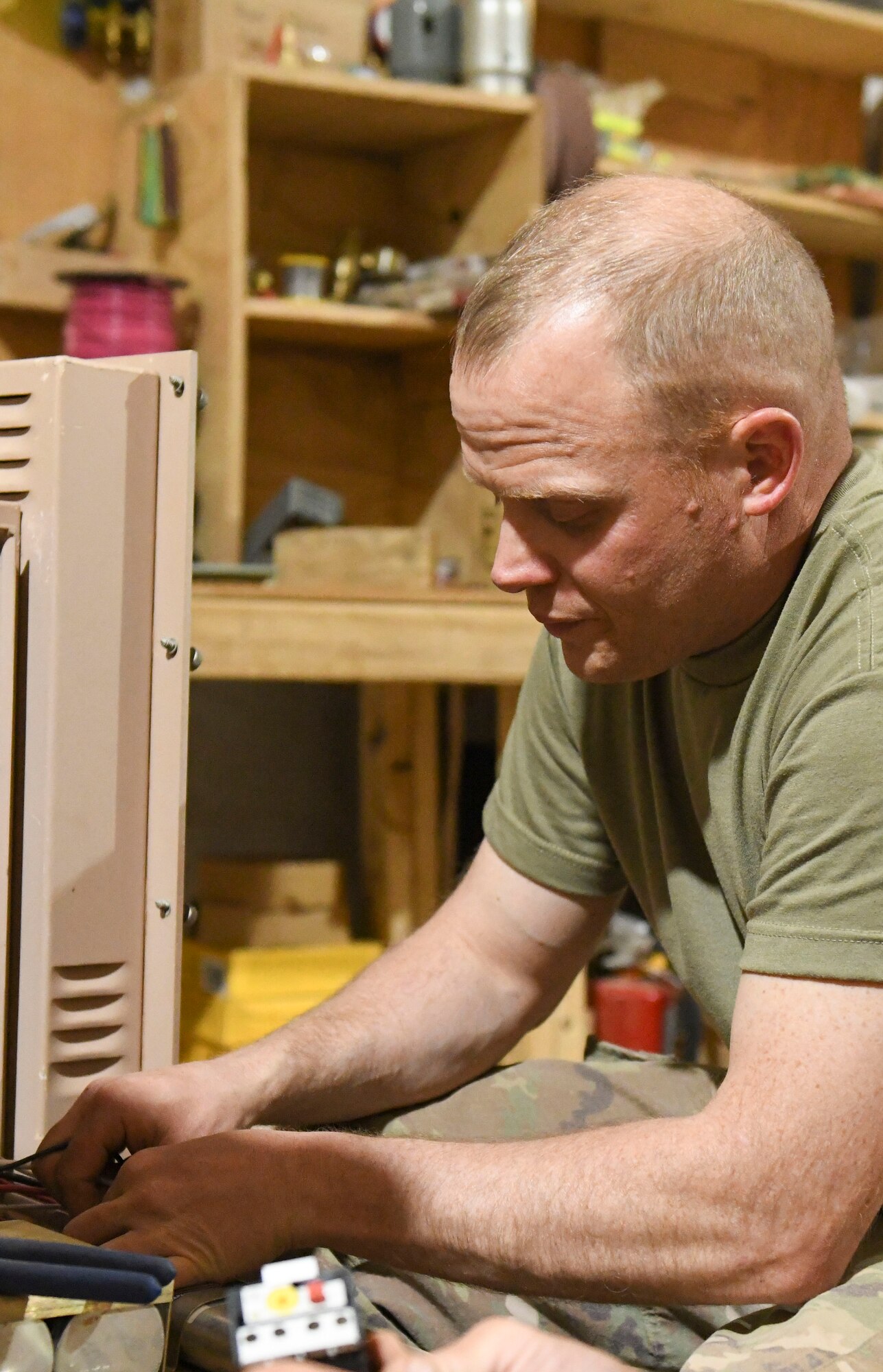 U.S. Air Force Tech. Sgt. Eric Smith, 724th Expeditionary Air Base Squadron Civil Engineer Flight heating, ventilation, air conditioning and refrigeration craftsman, troubleshoots and diagnoses an electrical problem on a field deployable environmental control unit at Nigerien Air Base 201, Agadez, Niger, Feb. 2, 2021. HVAC/R Airmen are responsible for installing, maintaining, and repairing all HVAC/R systems on base. (U.S. Air Force photo by Senior Airman Gabrielle Winn)