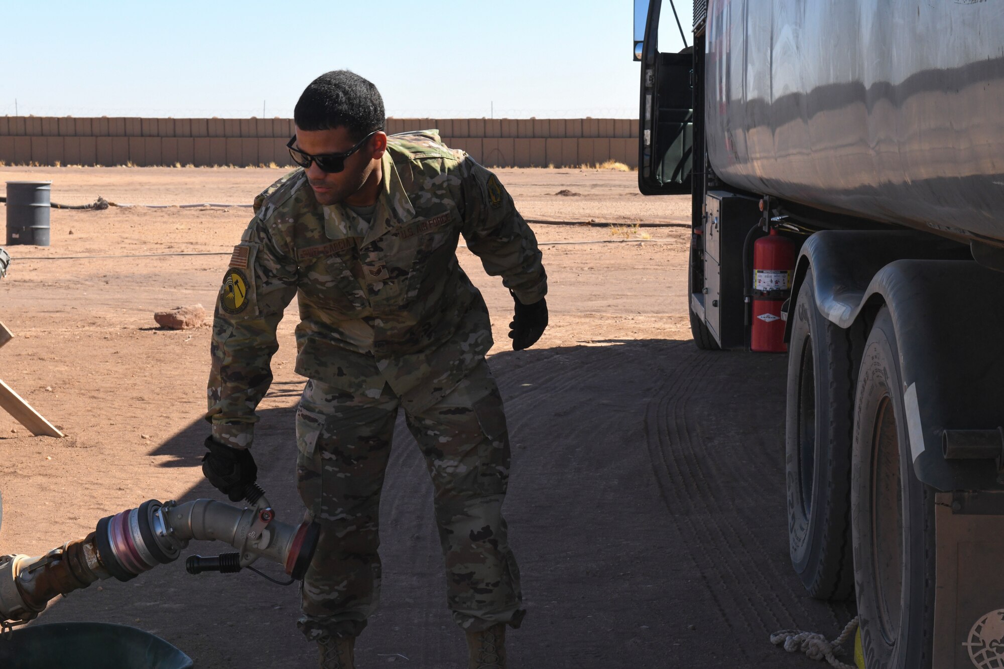U.S. Air Force Staff Sgt. Josue Ruiz-Garcia, 724th Expeditionary Air Base Squadron fuel operations noncommissioned officer in charge, attaches a fuel pump hose to an R-11 fuels truck at Nigerien Air Base 201, Agadez, Niger, Feb. 2, 2021. The petroleum, oils, and lubrication fuels section is responsible for fueling all vehicles and aircraft at Air Base 201. (U.S. Air Force photo by Senior Airman Gabrielle Winn)