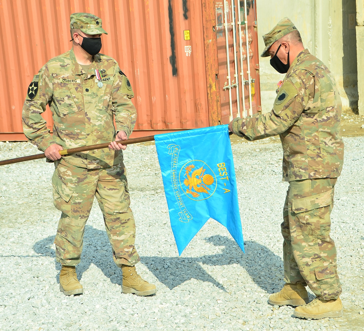 Lt. Col. Jason Osberg, of Champaign, Illinois, Commander Bilateral Embedded Support Team A25, and Master Sgt. Adam Abdul, of Collinsville, Illinois, prepare to case the BEST A colors during the decommissioning ceremony at Bagram Airfield, Afghanistan.