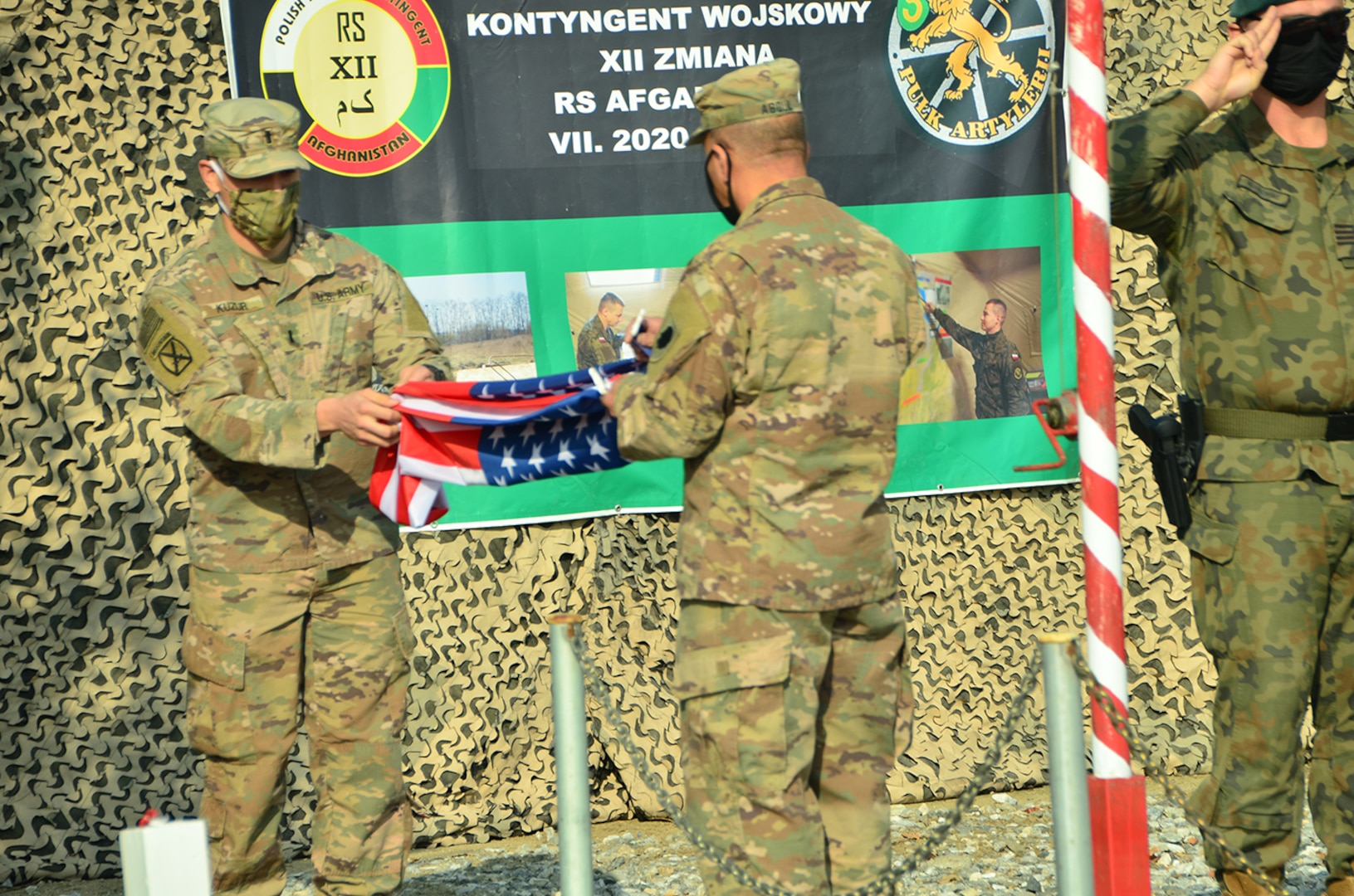 1st Lt. Kurt Kuzur, of Tinley Park, Illinois and Master Sgt. Adam Abdul, of Collinsville, Illinois, fold the U.S. flag during the Illinois Army National Guard Bilateral Embedded Staff Team (BEST) A25 decommissioning ceremony at Bagram Airfield, Afghanistan.