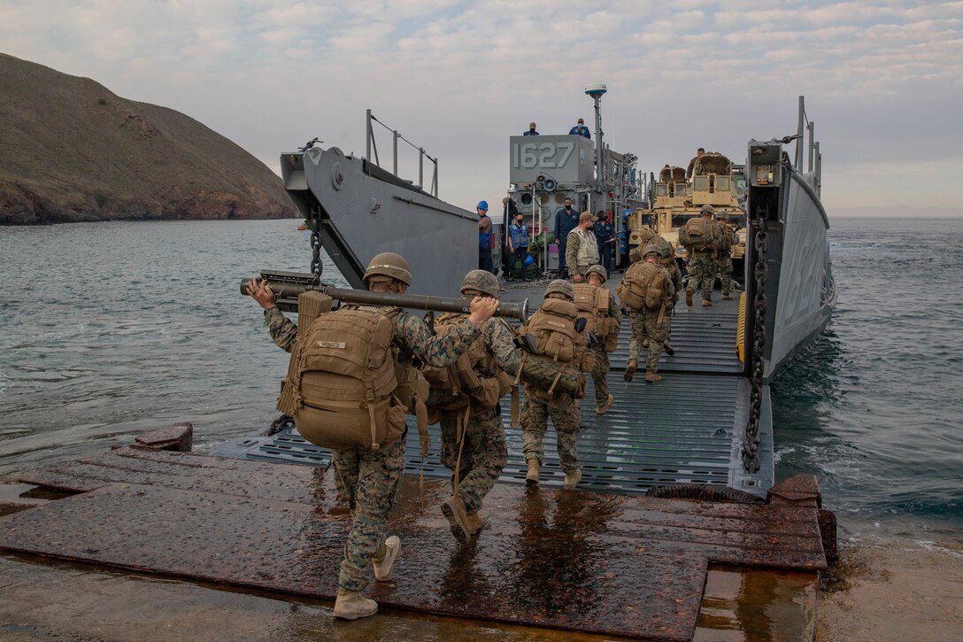 U.S. Marines and Sailors with 1st Battalion, 5th Marines, 1st Marine Division, board a landing craft, utility (LCU) during exercise Steel Knight/Dawn Blitz (SK/DB) 21 on San Clemente Island Dec. 8, 2020. DB/SK21 ensures the 1st Marine Division/ESG-3 team is optimized for naval expeditionary warfare in contested spaces and is purpose-built to facilitate sea denial and assured access in support of the naval fleet. (U.S. Marine Corps photo by Lance Cpl. Cameron Rowe)