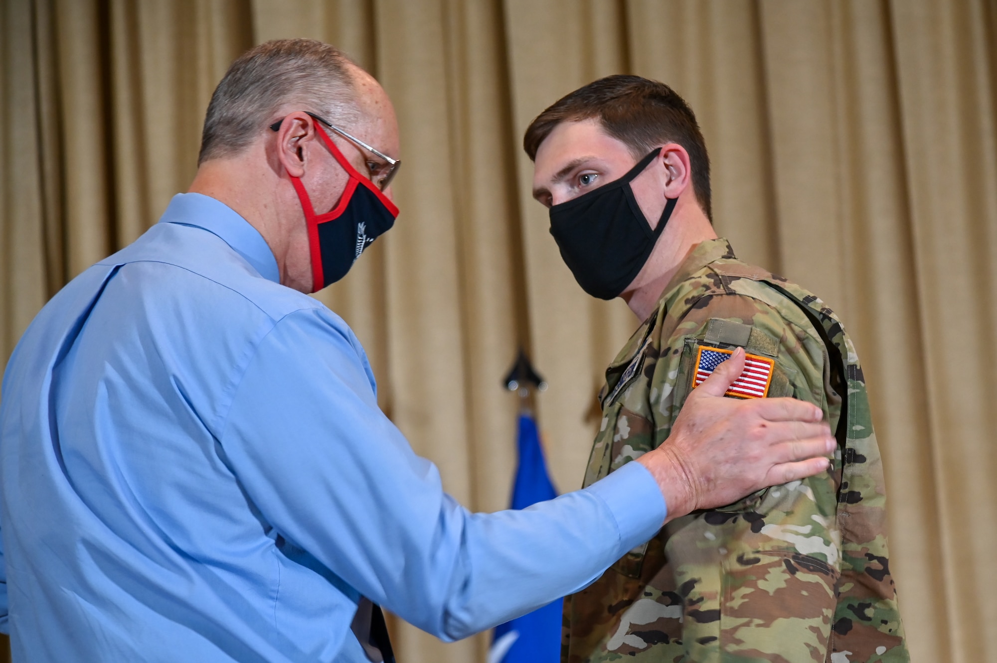 Second Lt. Matthew Farnya, Air Force Life Cycle Management Center, gets his patches replaced by his father