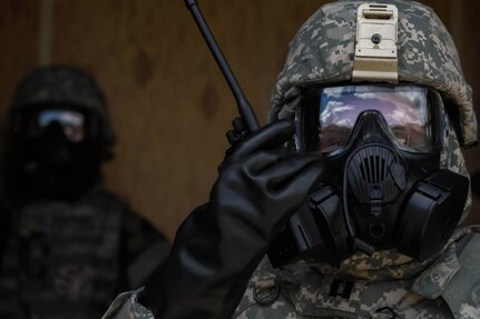 Service member performs training exercise to practice wearing CBRN protective gear.