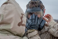 Service member performs training exercise to practice wearing CBRN protective gear.