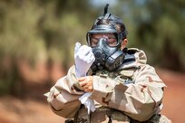Service member performs training exercise to practice wearing CBRN protective gear.