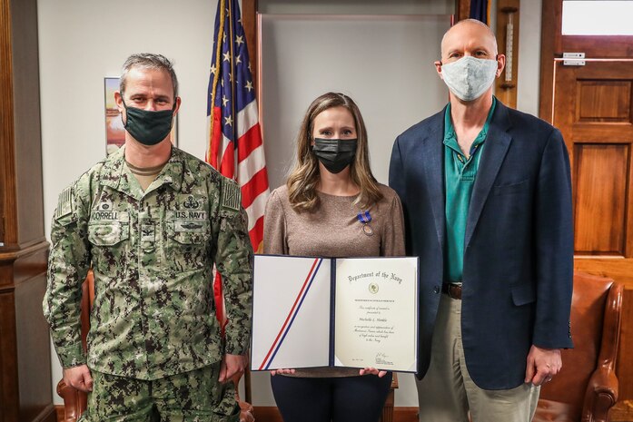 Naval Surface Warfare Center Indian Head Division (NSWC IHD) Commanding Officer Capt. Eric Correll (left) and Technical Director Ashley Johnson (right) present Workforce Development Branch Manager Michelle Hinkle with the Navy Meritorious Civilian Service Award, Feb. 4. Hinkle was recognized for her role in significantly improving training and processes in NSWC IHD’s Workforce Development Branch.