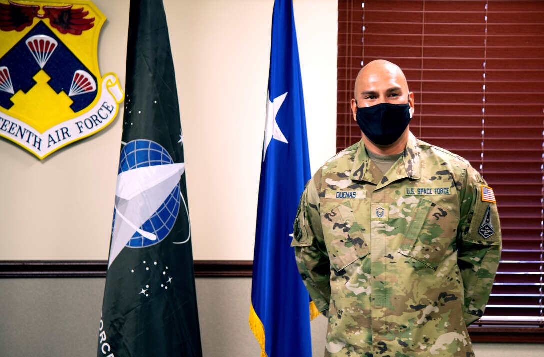 Air Force master sergeant poses for photo near U.S. Space Force flag