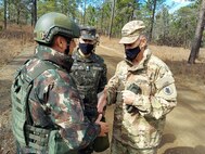 Maj. Gen. Daniel R. Walrath, right, U.S. Army South commanding general, greets a Brazilian Army soldier taking part in the bilateral training exercise at the Joint Readiness Training Center at Fort Polk, La., Feb. 2, as Lt. Gen. Lt. Gen. Marcos de Sá Affonso da Costa, chief of training, Land Forces Training Command, Exército Brasileiro, looks on.