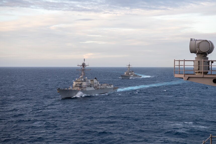 SOUTH CHINA SEA (Feb. 9, 2021) – The Arleigh Burke-class guided-missile destroyer USS John Finn (DDG 113), left, and the Arleigh Burke-class guided-missile destroyer USS Russell (DDG 59) move into formation alongside the aircraft carrier USS Theodore Roosevelt (CVN 71) during dual-carrier operations with the Nimitz Carrier Strike Group in the South China Sea Feb. 9, 2021. The Theodore Roosevelt and Nimitz Carrier Strike Groups are conducting dual-carrier operations during their deployments to the 7th Fleet area of operations. As the U.S. Navy's largest forward-deployed fleet, 7th Fleet routinely operates and interacts with 35 maritime nations while conducting missions to preserve and protect a free and open Indo-Pacific Region. (U.S. Navy photo by Mass Communication Specialist Seaman Deirdre Marsac)