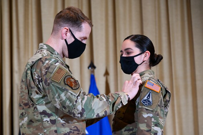 Sergeant Roxanne Esler-Groschel, 729th Air Control Squadron, has her patches replaced by her husband, Tech. Sgt. Scott Esler