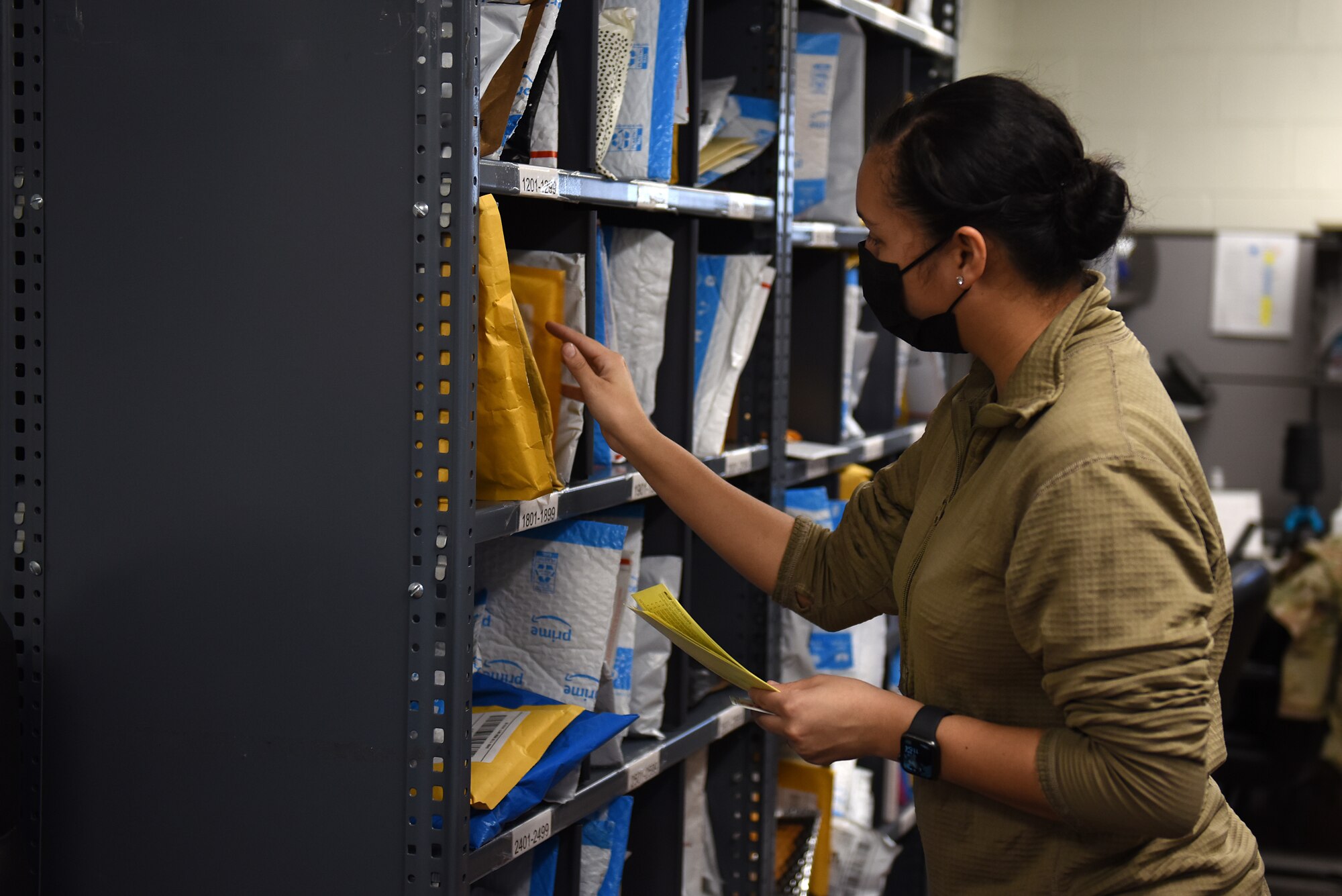 Staff Sgt. Ana Frye, 8th Force Support Squadron registered mail NCO in-charge, retrieves a package inside the post office at Kunsan Air Base, Republic of Korea, Feb. 3, 2021. With a staff of 11 the post office receives and distributes approximately 5,000 packages a week to the members of Kunsan.