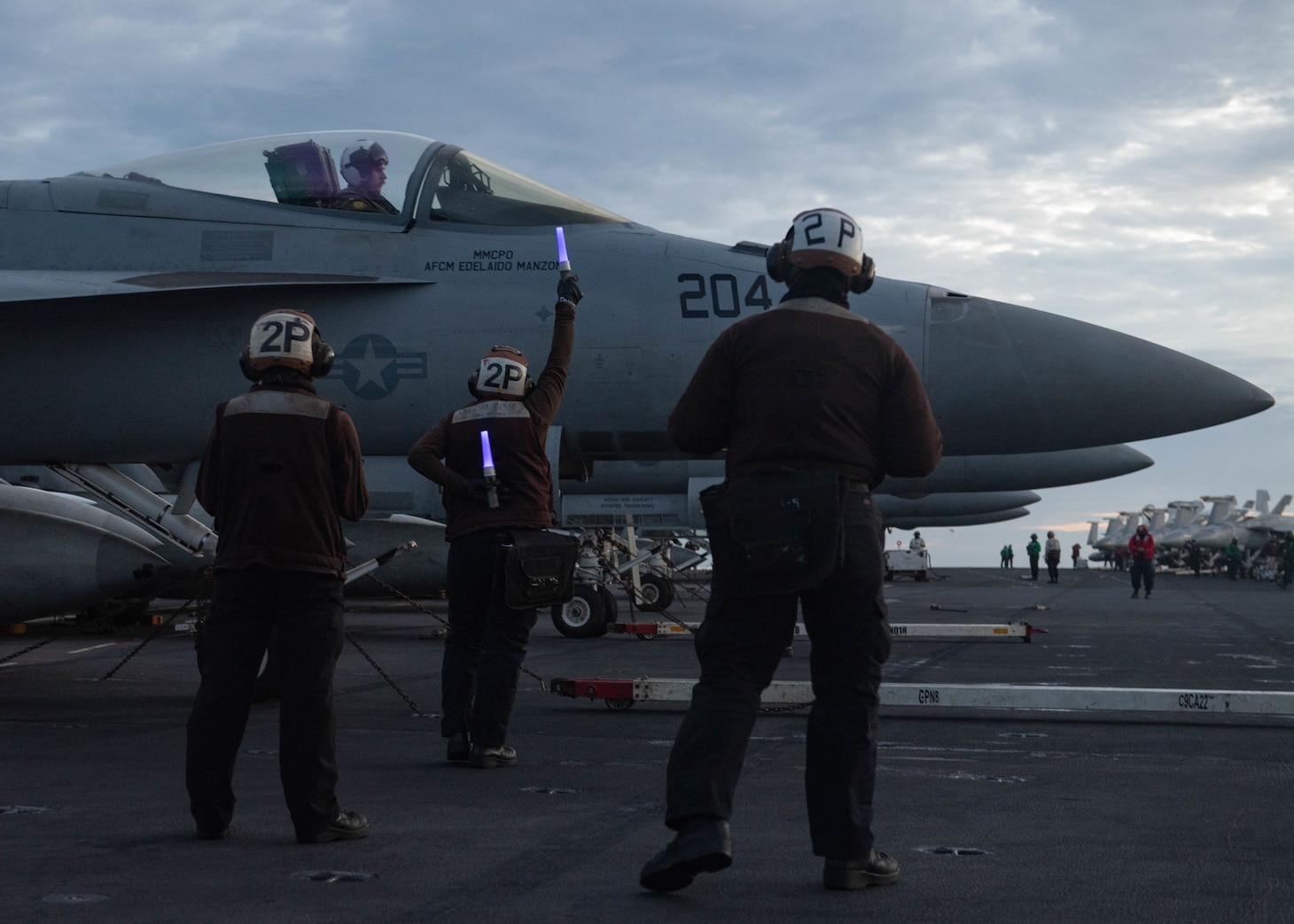 SOUTH CHINA SEA (Feb. 9, 2021) U.S. Sailors signal the pilot of an F/A-18E Super Hornet, assigned to the “Tomcatters” of Strike Fighter Squadron (VFA) 31, while conducting dual-carrier operations with the Nimitz Carrier Strike Group in the South China Sea Feb. 9, 2021. The Theodore Roosevelt and Nimitz Carrier Strike Groups are conducting dual-carrier operations during their deployments to the 7th Fleet area of operations. As the U.S. Navy’s largest forward-deployed fleet, 7th Fleet routinely operates and interacts with 35 maritime nations while conducting missions to preserve and protect a free and open Indo-Pacific region. (U.S. Navy photo by Mass Communication Specialist 2nd Class Zachary Wheeler)