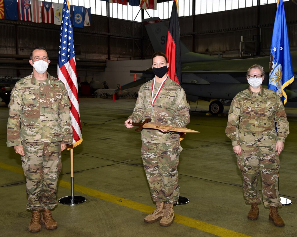 U.S. Air Force Col. Jason Hokaj, 52nd Fighter Wing vice commander (left), and Chief Master Sgt. Stephanie Cates, 52nd Fighter Wing command chief (right), give the First Sergeant of the Year award to U.S. Air Force Senior Master Sgt. Lyndsey Lemus, 52nd Mission Support Group, Feb. 5, 2021, at Spangdahlem Air Base, Germany.