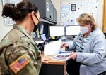 Gabriele Harrison (right), host nation patient liaison supervisor and transfer coordinator, Landstuhl Regional Medical Center, discusses care options with a patient during a patient encounter at LRMC.