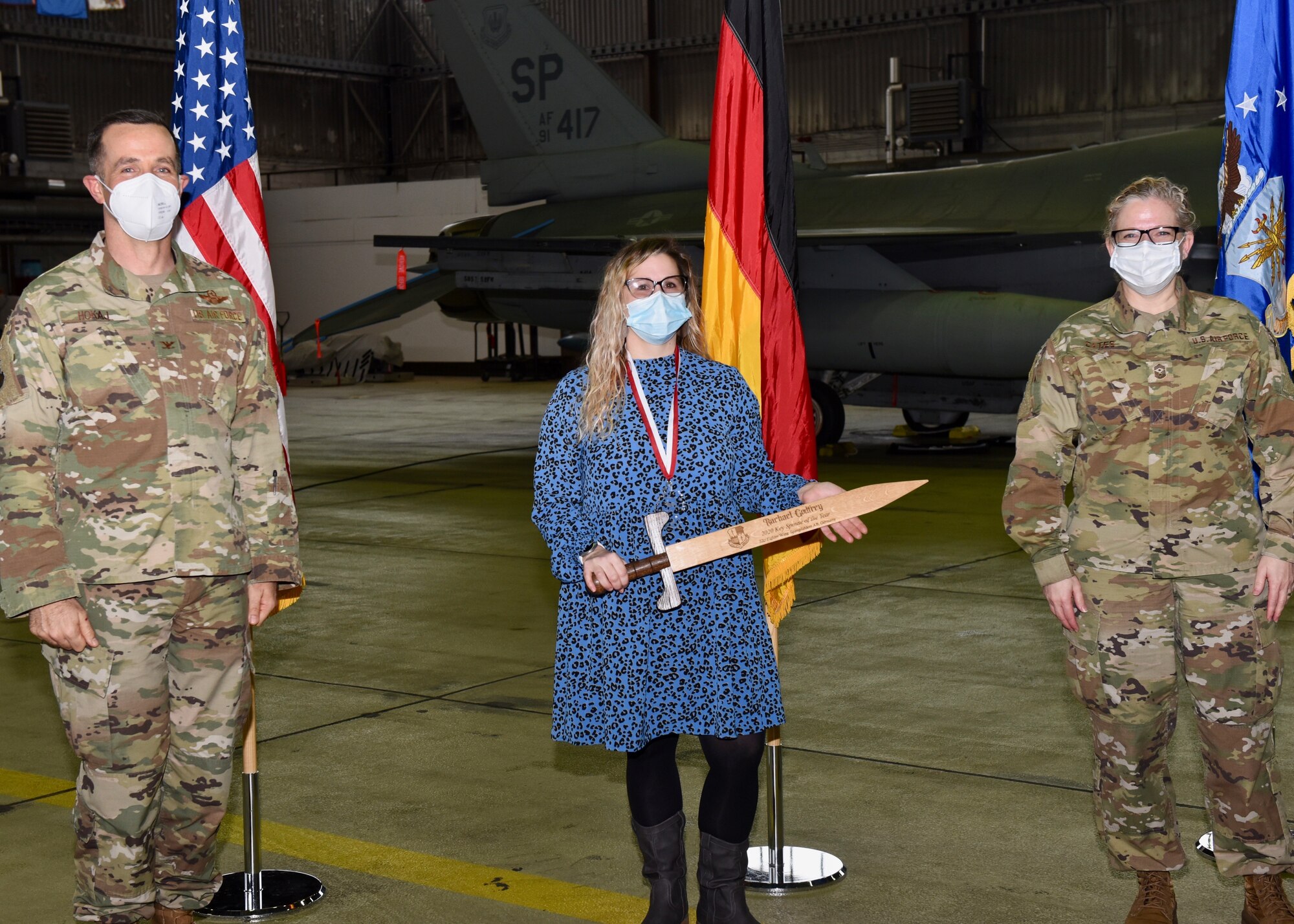U.S. Air Force Col. Jason Hokaj, 52nd Fighter Wing vice commander (left), and Chief Master Sgt. Stephanie Cates, 52nd Fighter Wing command chief (right), give the Key Spouse of the Year award to Racheal Godfrey, 52nd Fighter Wing, Feb. 5, 2021, at Spangdahlem Air Base, Germany.