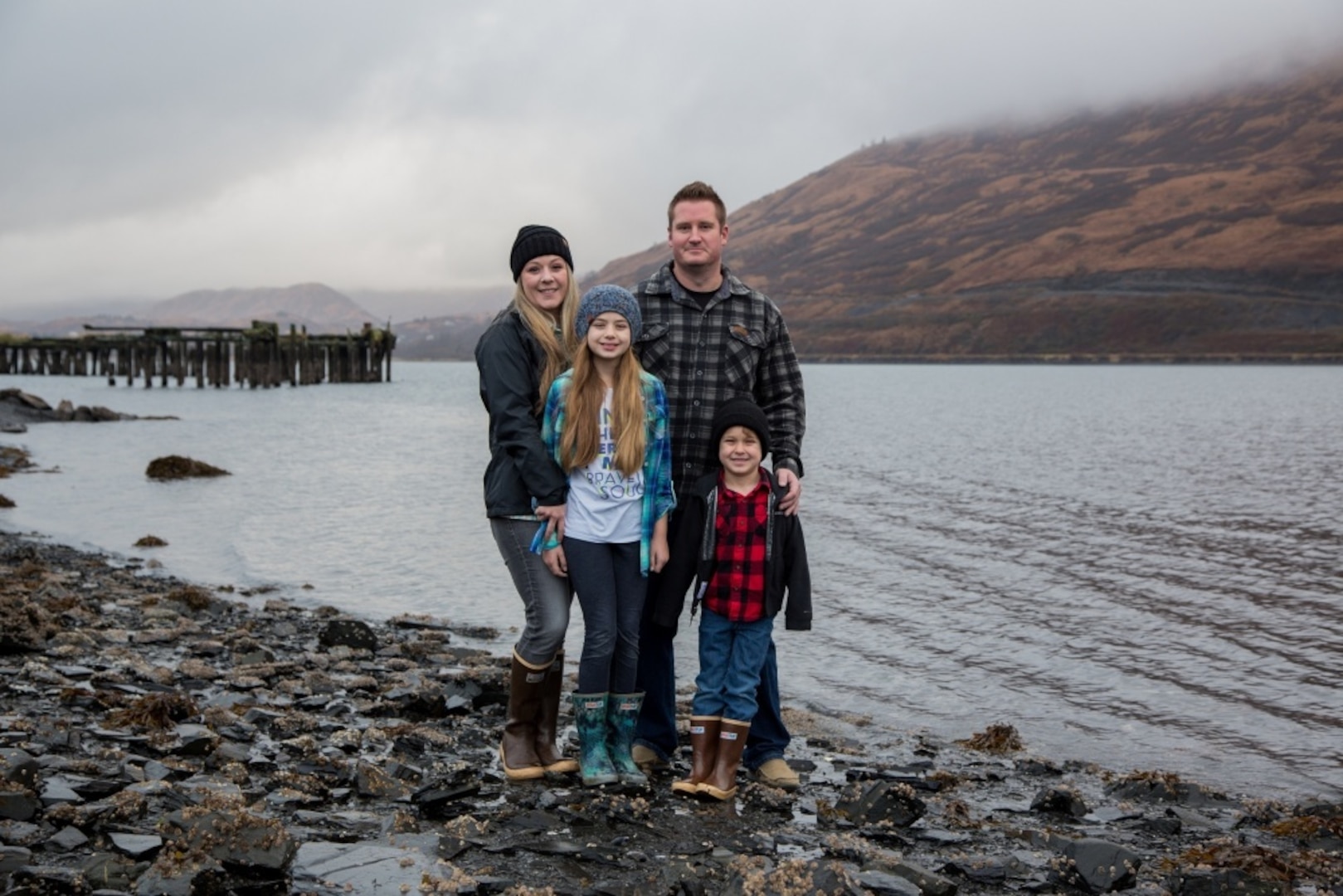 Coast Guard Petty Officer 1st Class Casey Lawrence and her spouse, Justin, also a Coast Guard member, stand with their children on Base Kodiak, Alaska, Nov. 3, 2018. Casey and her family enjoy all that Kodiak has to offer and they recently purchased their retirement home in Kodiak. U.S. Coast Guard photo by Petty Officer 1st Class Charly Hengen.