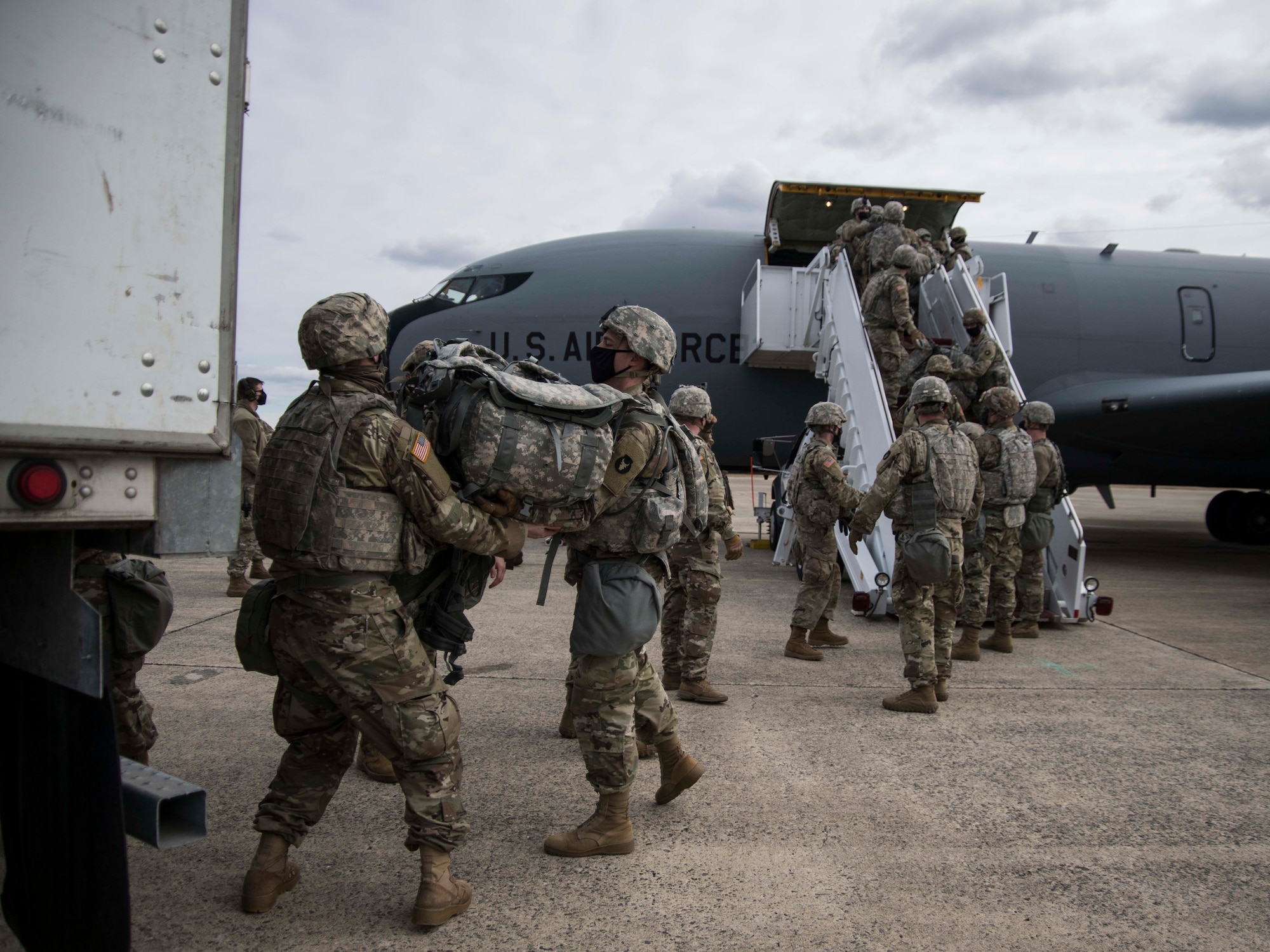 U.S. Soldiers with the Iowa National Guard unload cargo from a KC-135 Stratotanker upon arrival to Joint Base Andrews, Maryland, Jan. 18, 2021. At least 25,000 National Guard men and women have been authorized to conduct security, communication and logistical missions in support of federal and District authorities leading up and through the 59th Presidential Inauguration. (U.S. Air National Guard photo by Tech. Sgt. Morgan R. Whitehouse)