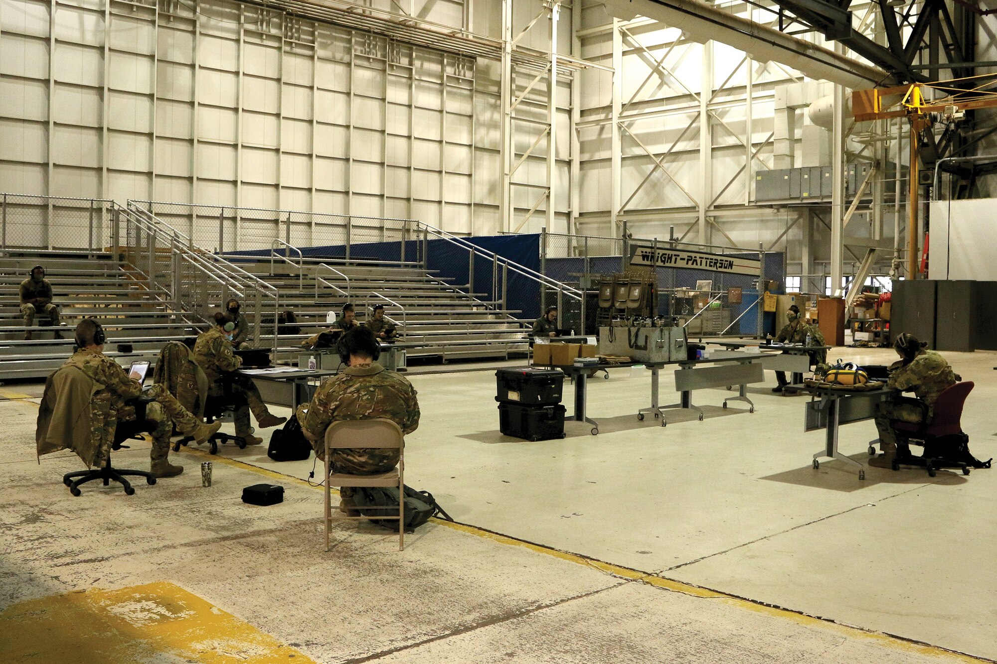 Members of the 445th Aeromedical Evacuation Squadron hold a mission brief in a maintenance bay at Wright-Patterson Air Force Base, Ohio, before heading out on a training flight Jan. 9, 2021. The members socially distanced, wore masks and used their internal radio systems to communicate with each other.