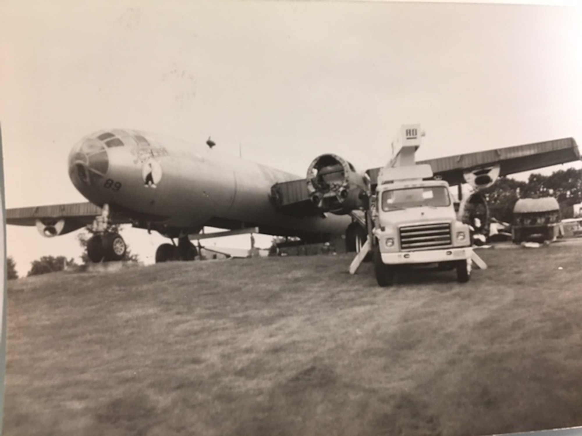 A truck sits in front of a partially deconstructed B-29 Superfortress on a hill.