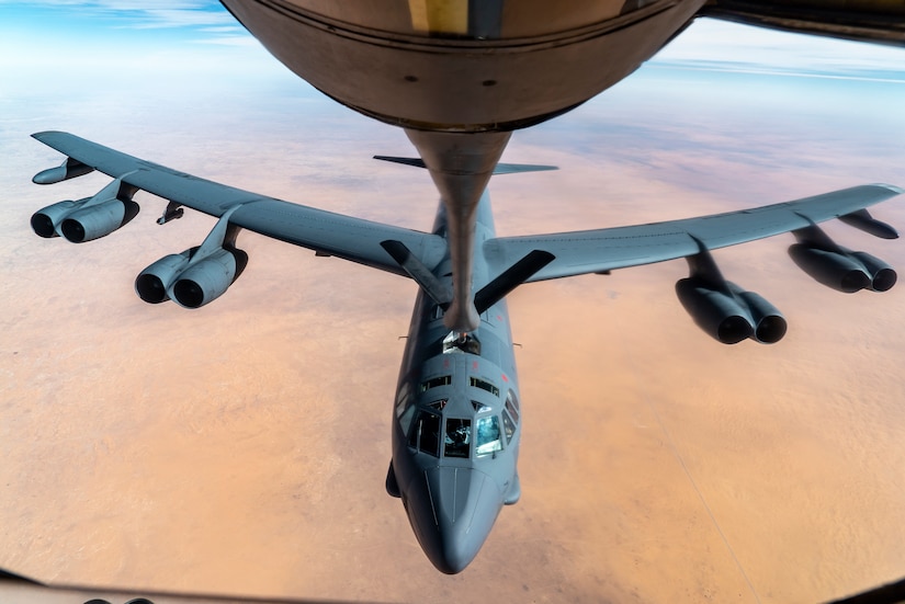 A refueling line extends to a bomber for mid-air refueling.
